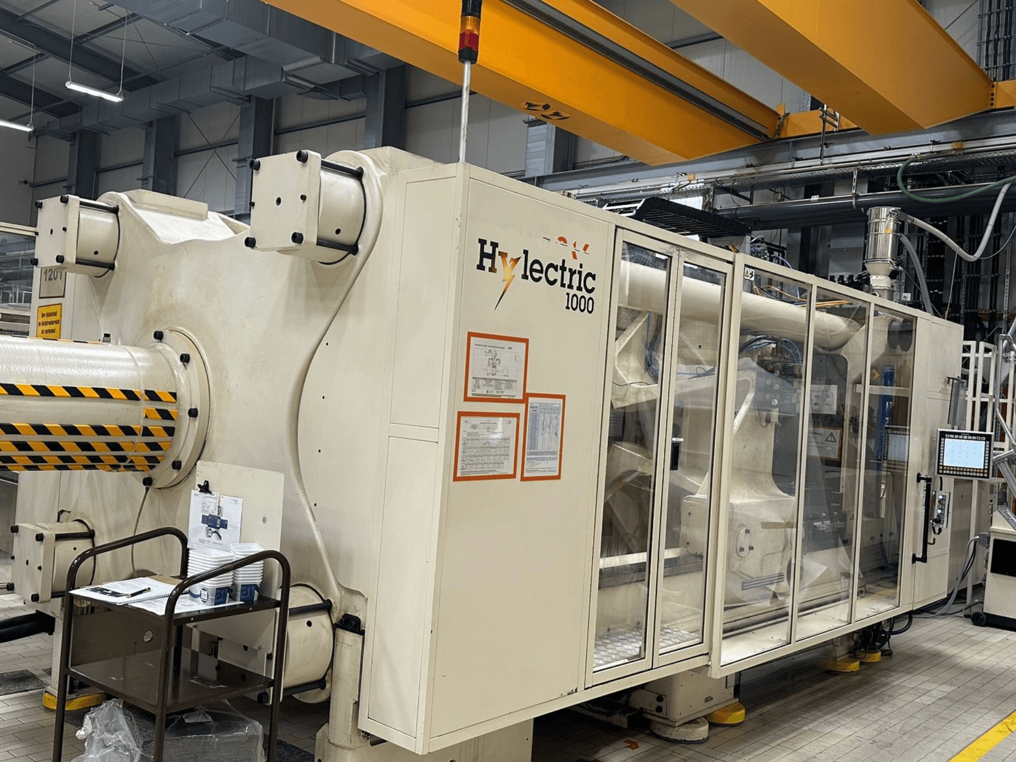 Elektrinė liejimo mašina „Husky Hylelectric H1000 RS95/80“, vaizdas iš šono, kuriame matomas valdymo skydas ir saugos įranga.
