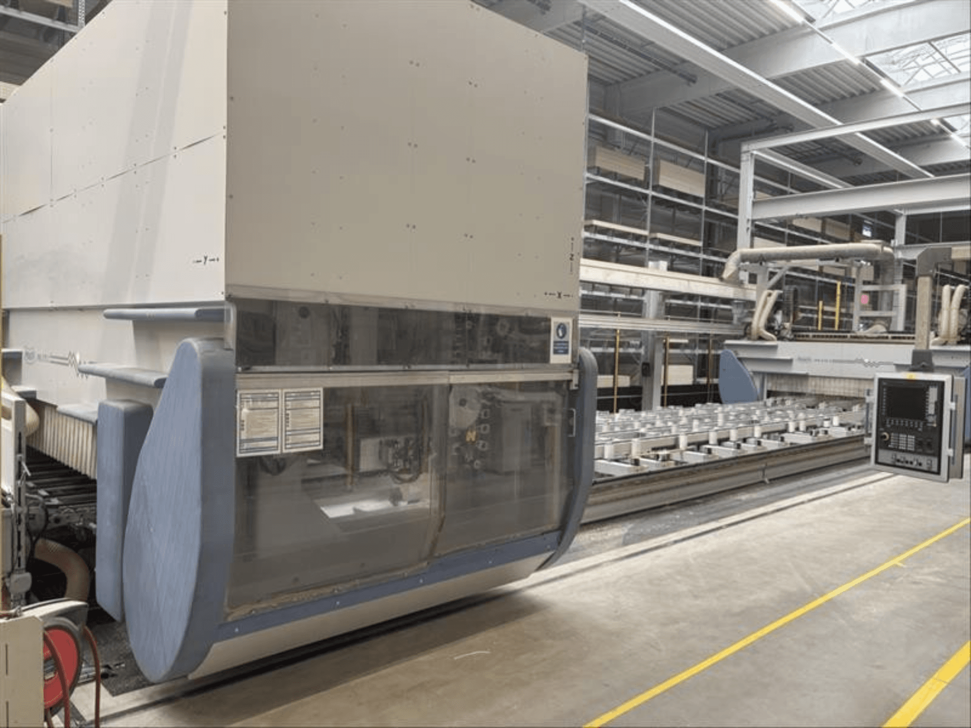 CNC apdirbimo centras MAKA PM 270 X, priekinis vaizdas, kuriame matomas valdymo skydelis ir mašinų detalės gamykloje.