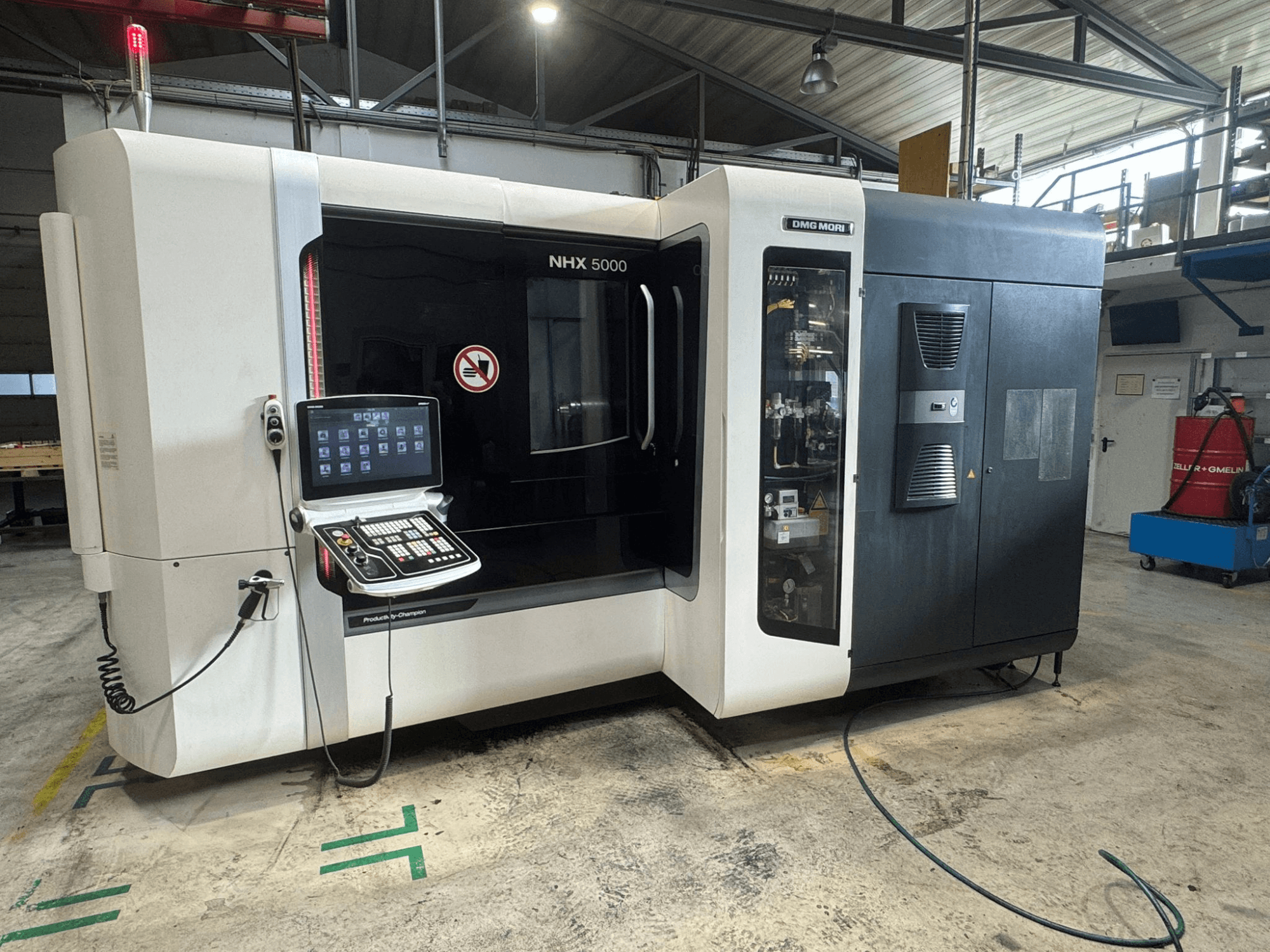 DMG MORI NHX 5000 horizontalusis apdirbimo centras, vaizdas iš priekio, matomas valdymo skydelis ir saugos indikatoriai.