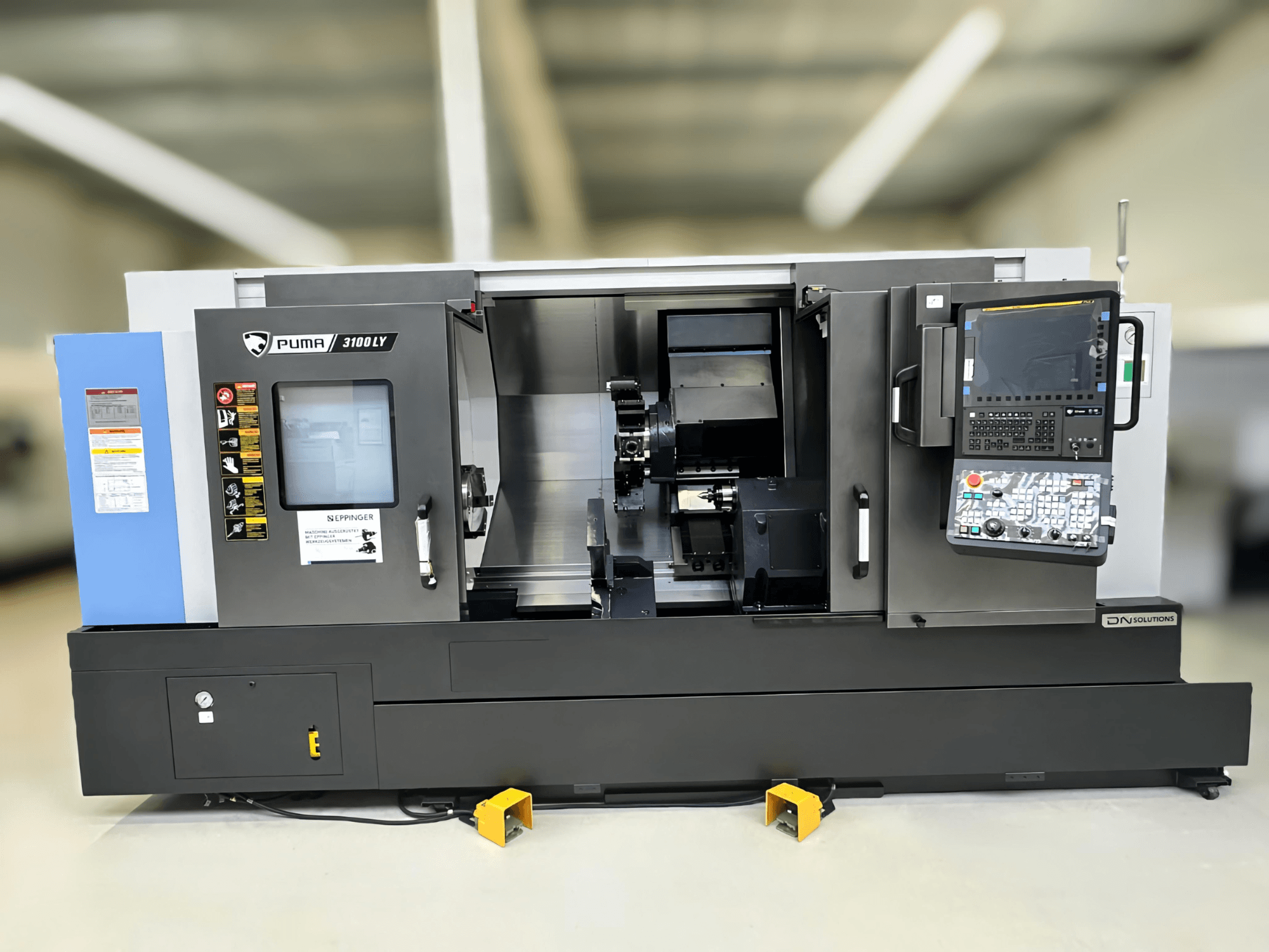 DN SOLUTIONS Puma 3100 LY tekinimo frezavimo centro "Puma 3100" priekinis vaizdas, kuriame matomas valdymo skydelis, suklys ir valdymo funkcijos.