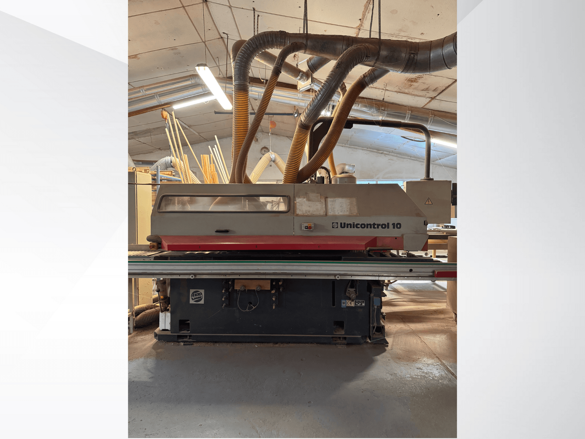 Medienos apdirbimo staklių "Unicontrol 10" vaizdas iš priekio su dulkių ištraukimo vamzdeliais ir darbiniais valdikliais.