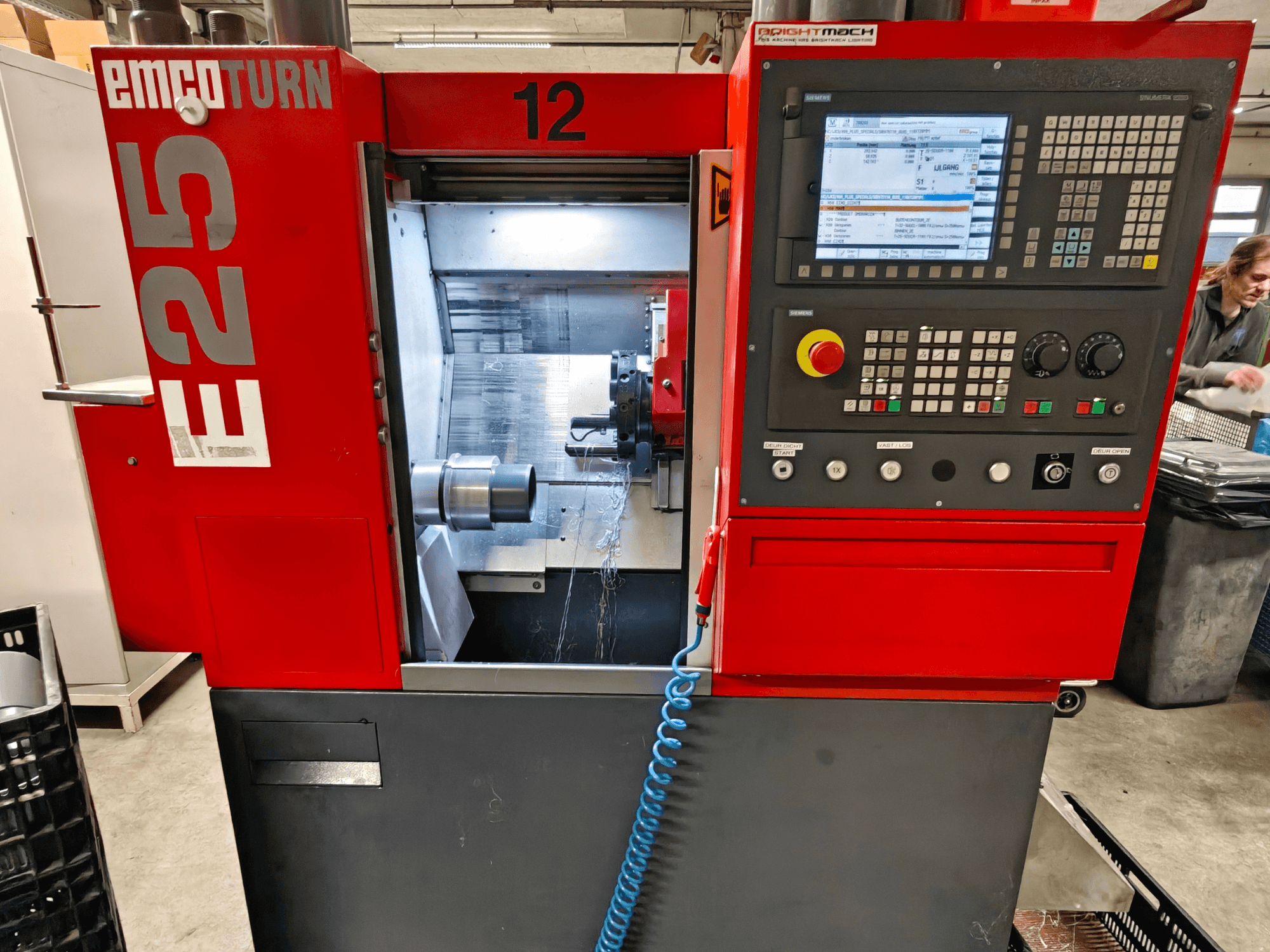 EMCO TURN E25 staklių priekinis vaizdas, kuriame matyti valdymo skydelis, įrankių laikiklis ir vidinė erdvė, kurioje matomas pjovimo įrankis.