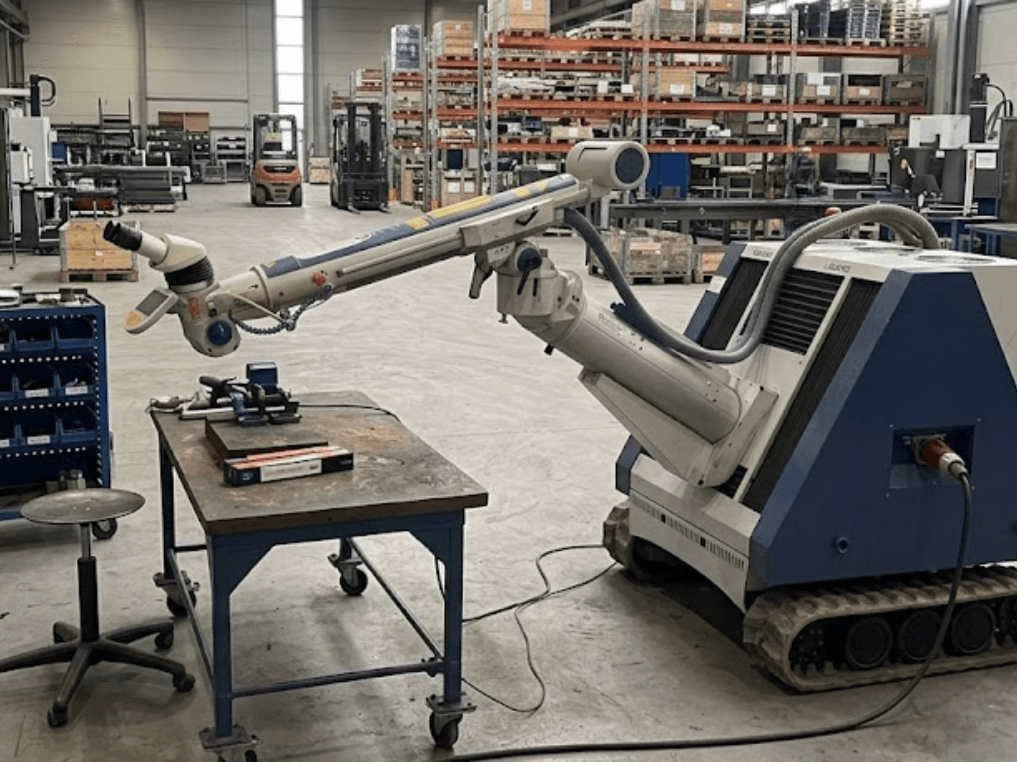 „ALPHA LASER ALFlak300 M“ staklės dirbtuvėse su robotine ranka; vaizdas iš priekio, kuriame matyti tikslus nustatymas ant darbo stalo.