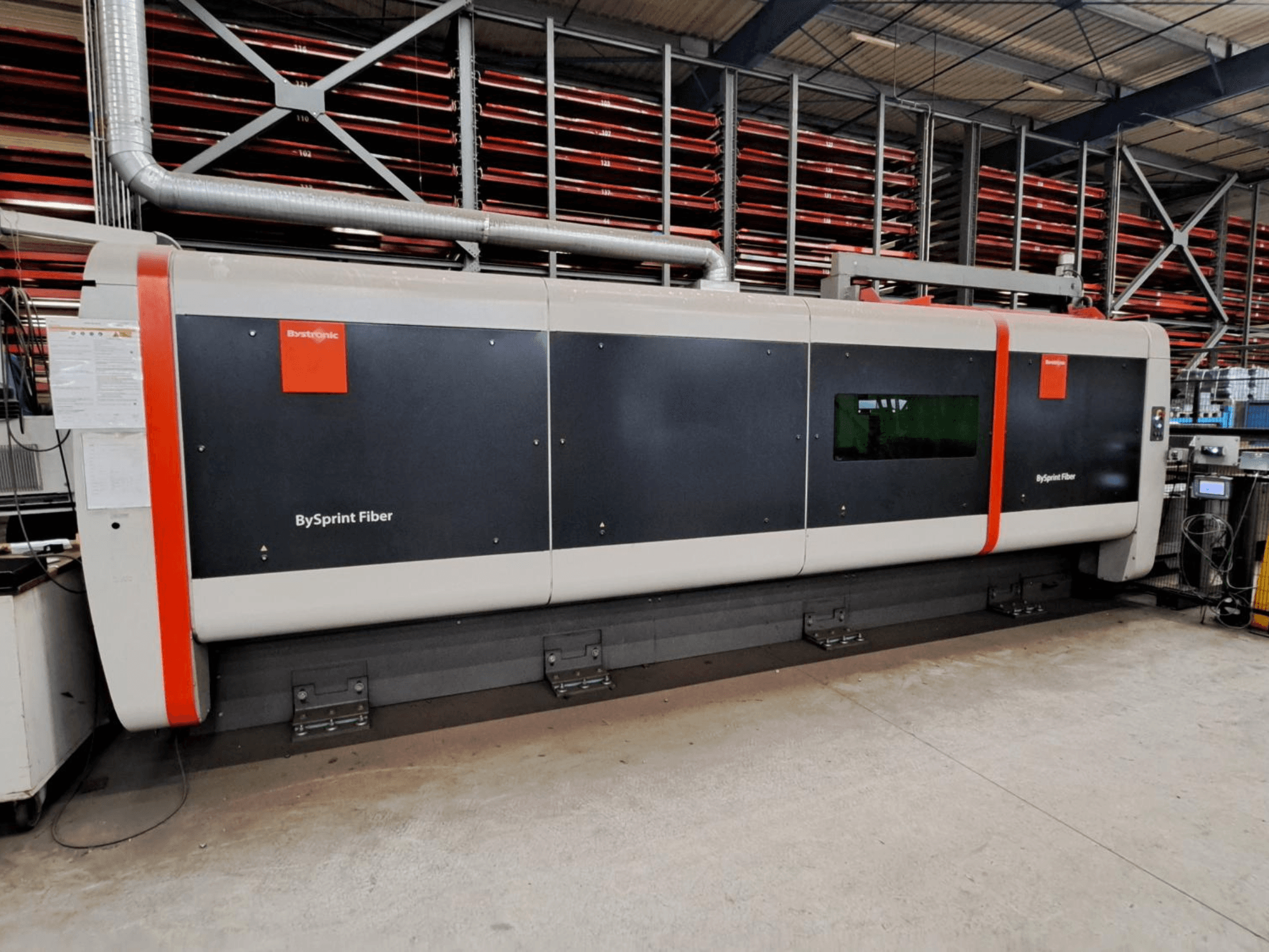 "Bystronic BySprint Fiber 4020" pluoštinio lazerio pjovimo staklės, vaizdas iš priekio dirbtuvėse, matomos saugos priemonės.