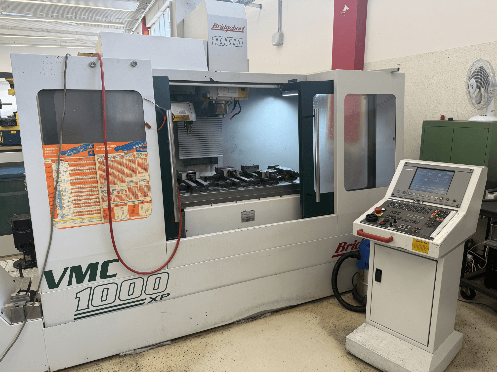 Vertikaliojo apdirbimo centro „Bridgeport VMC 1000 XP“ vaizdas iš priekio, kuriame matomi valdymo elementai, darbo zona ir įrankių tvirtinimo vietos.