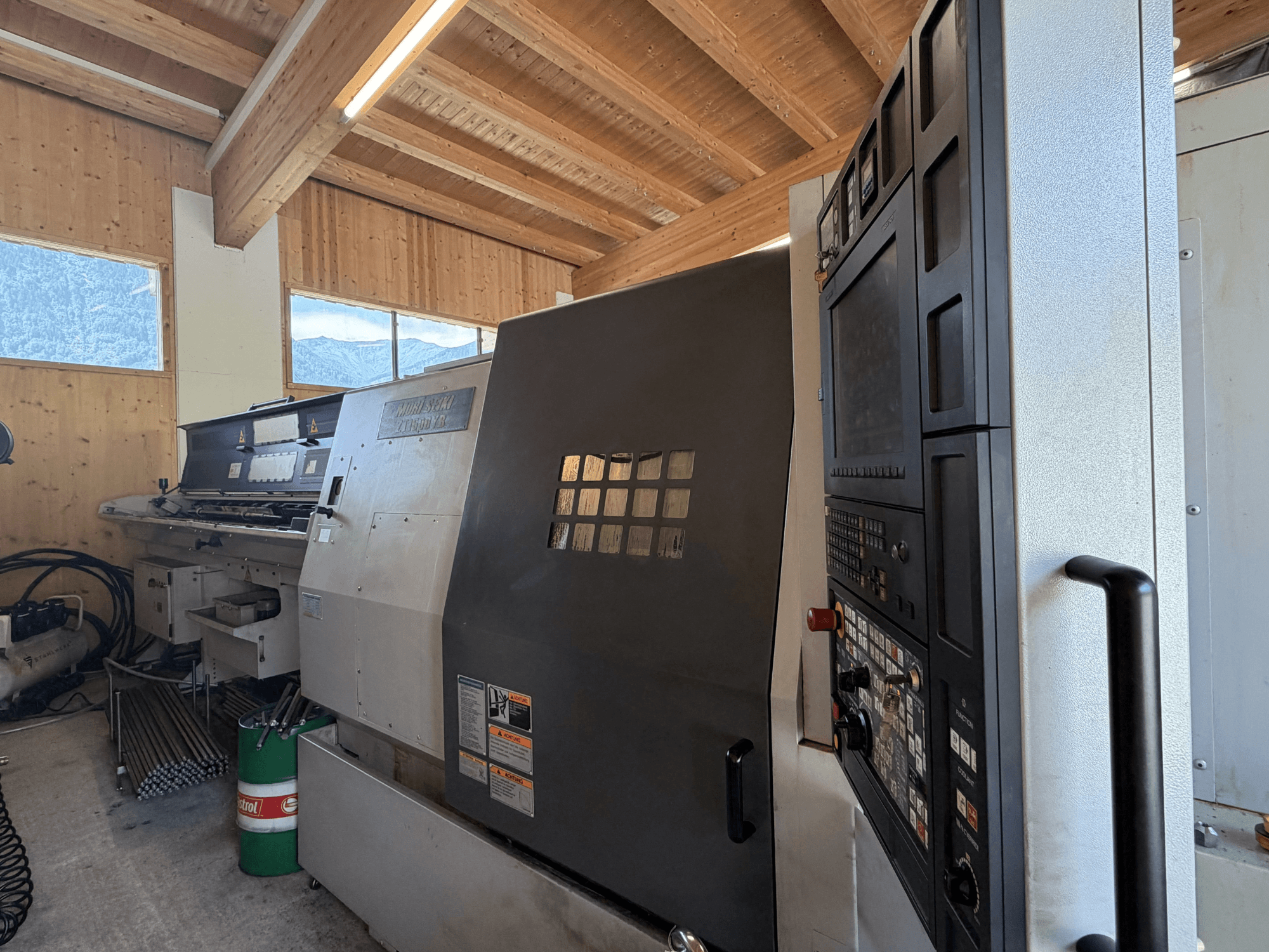MORI SEIKI ZT1500YB tekinimo-frezavimo centras dirbtuvėse, šoninis vaizdas, kuriame matomas valdymo pultas ir staklių ypatybės.