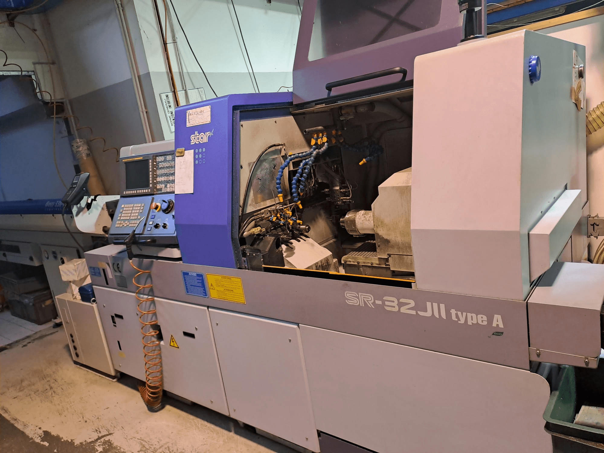 STAR MICRONICS SR-32JII tipoA šveicariško tipo tekinimo staklių šoninis vaizdas, kuriame matomas valdymo skydelis ir matomi apdirbimo komponentai.