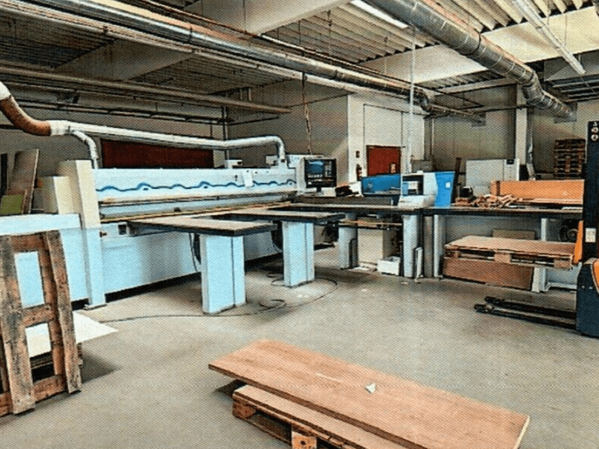 HOMAG HPL 11/38/22 plokščių pjūklas dirbtuvėse su dideliu pjovimo stalu ir demonstracine konsole, žiūrint iš priekio.