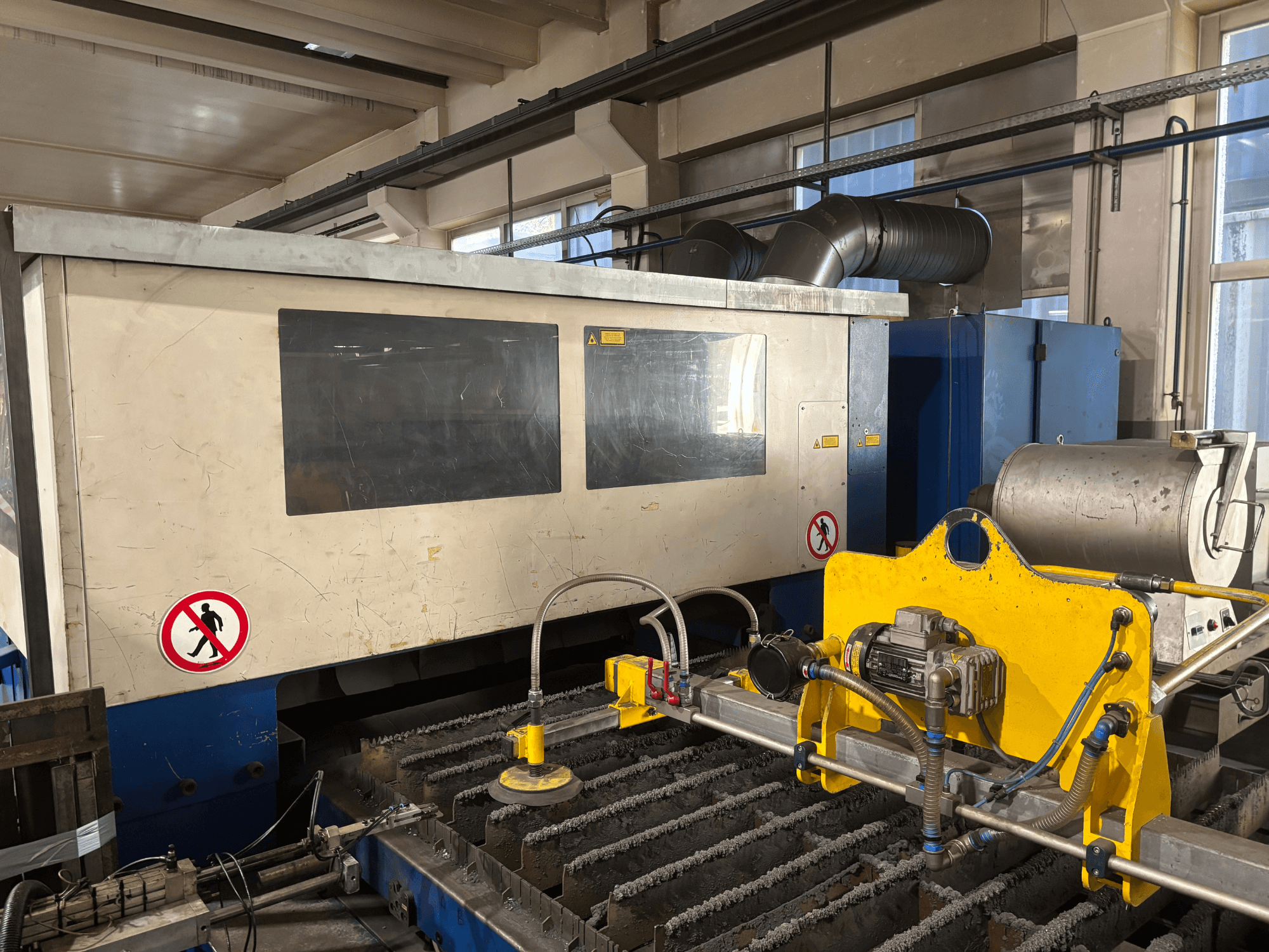 TRUMPF Trumatic L3030 CO2 lazerinio pjovimo staklės, priekinis vaizdas, kuriame matoma valdymo sąsaja ir pjovimo paviršiaus detalės.
