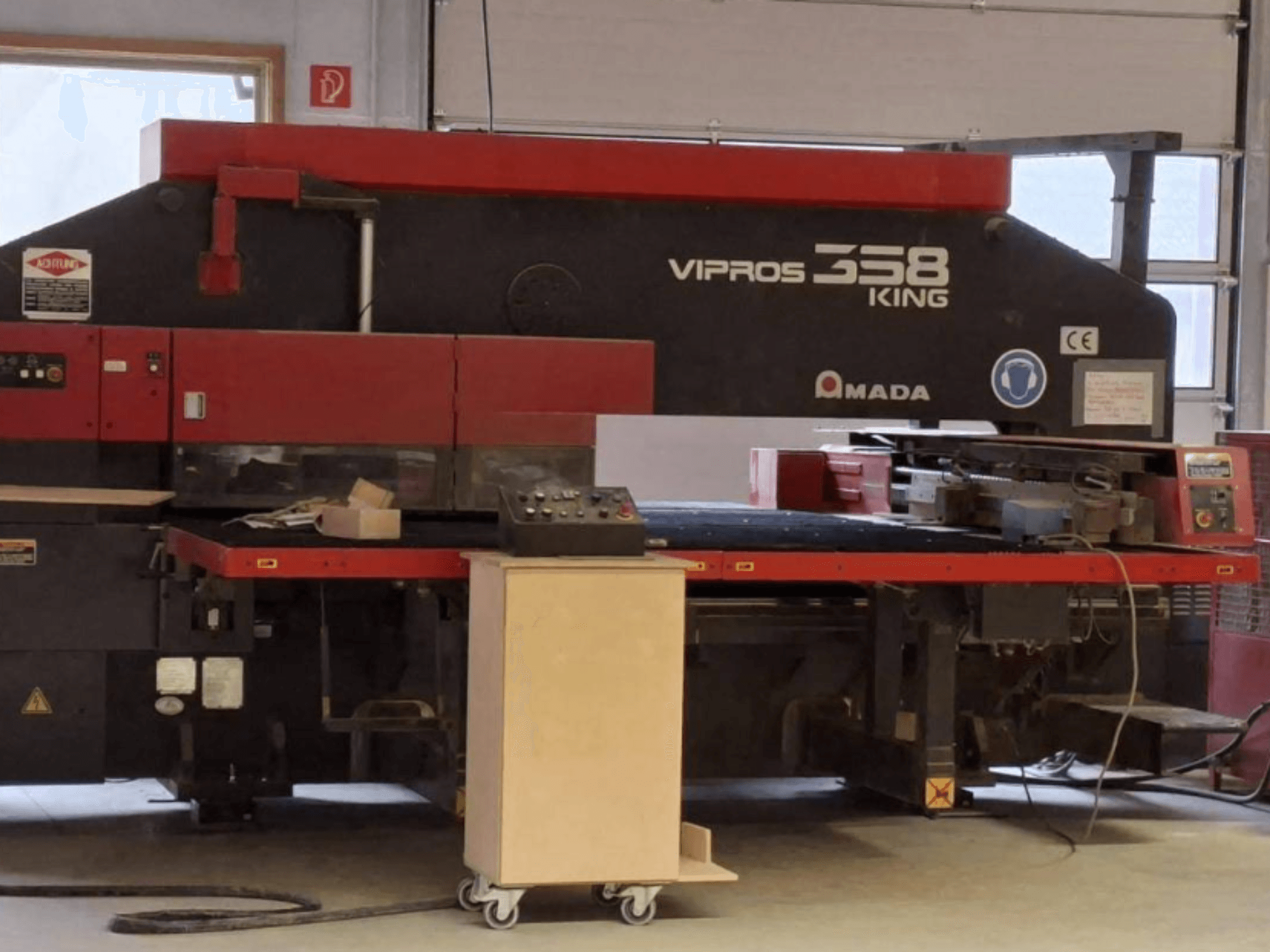 CNC štampavimo presas „AMADA VIPROS 358 KING“ iš šono, su valdymo pultu ir įrankių laikymo vieta.