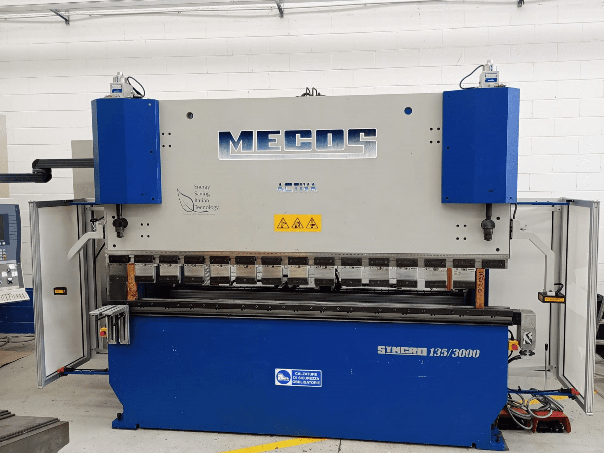 MECOS SYNCRO 135/3000 presų stabdžių priekinis vaizdas, kuriame matomi valdikliai, lenkimo įrankiai ir saugos funkcijos.