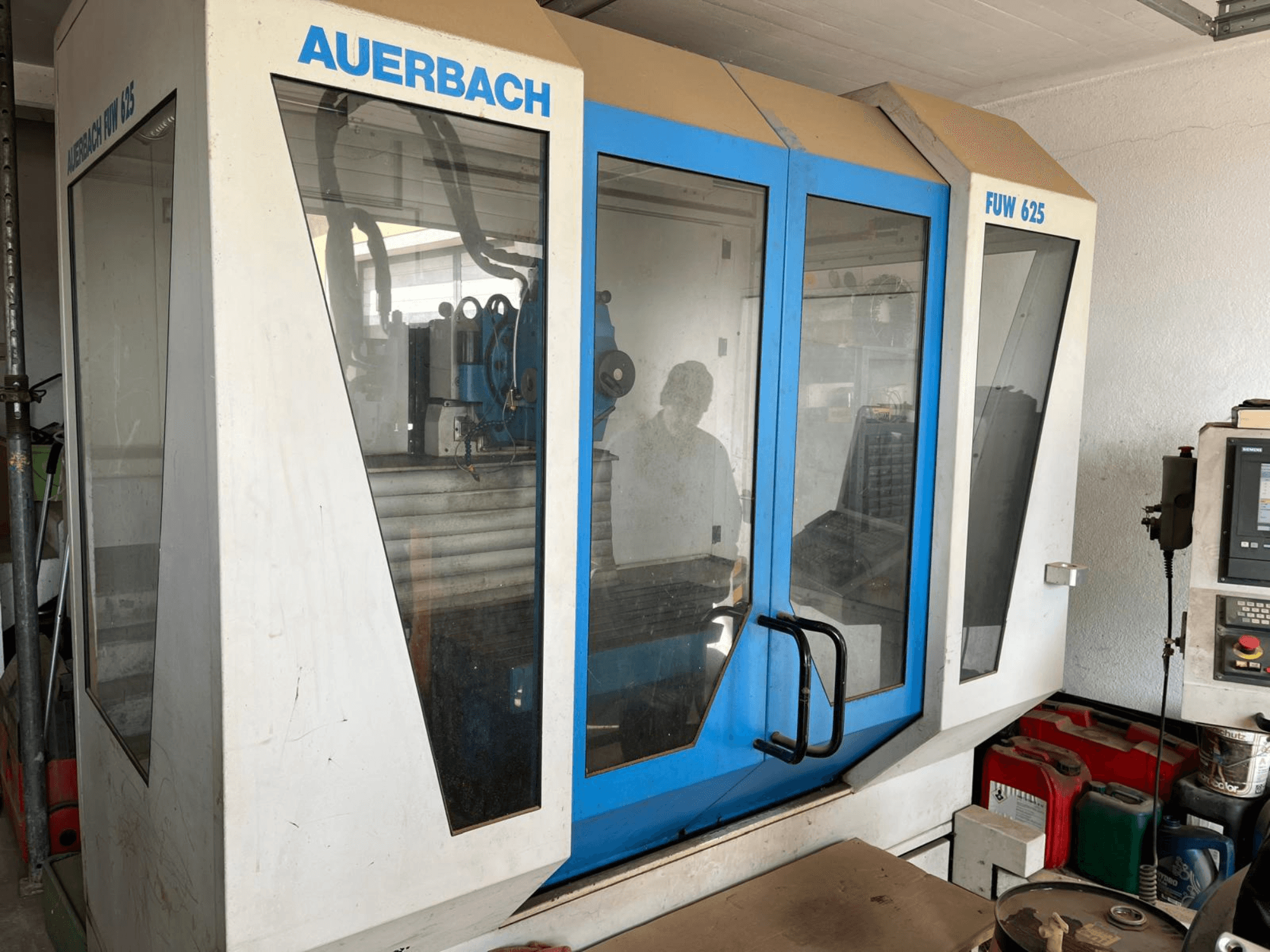 Auerbach FUW 625 universalus apdirbimo centras šoniniu vaizdu, su stiklinėmis plokštėmis ir valdymo pultu dešinėje.
