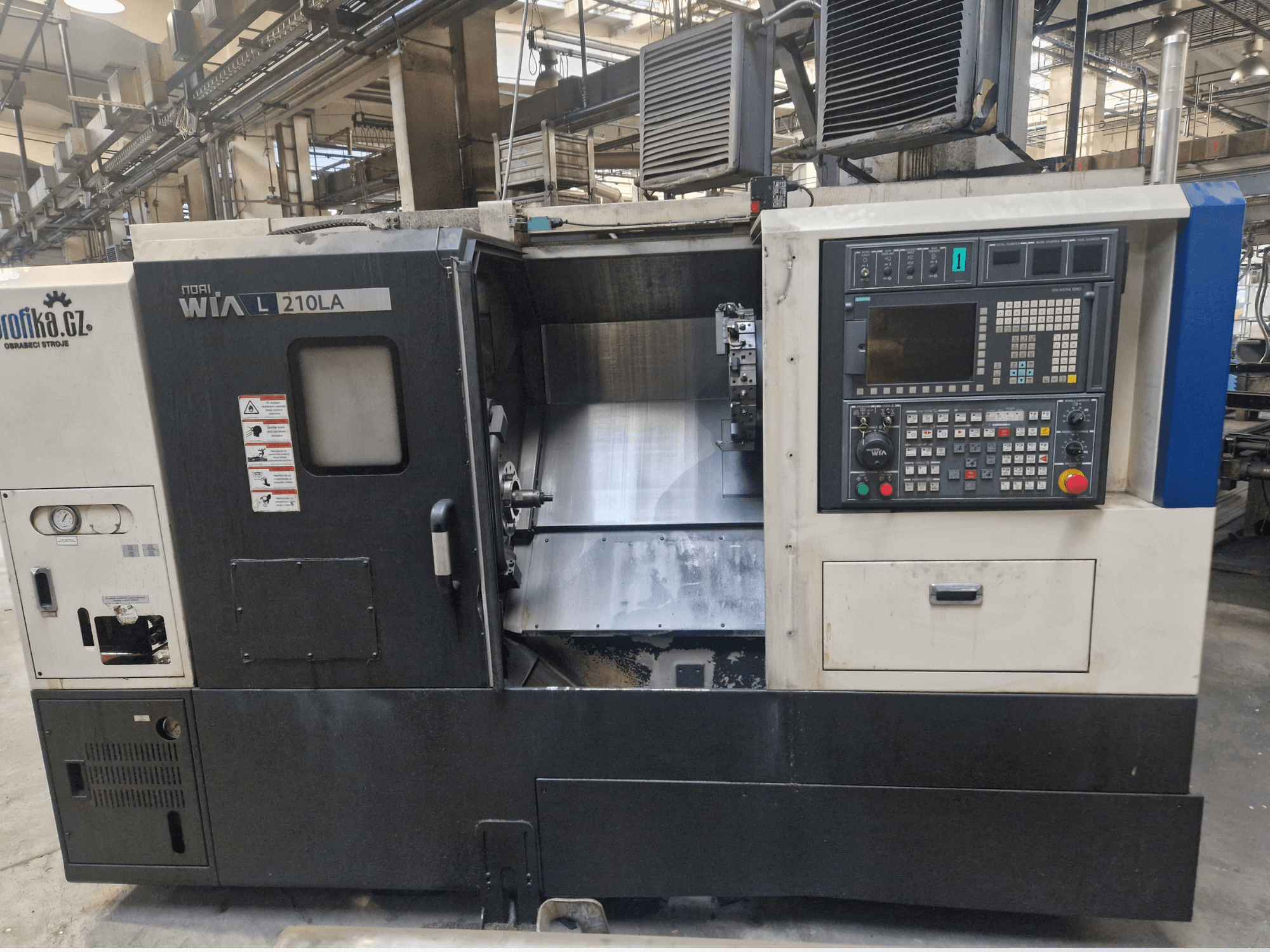 WIA L210LA CNC tekinimo staklės, vaizdas iš priekio, valdymo skydelis su mygtukais, ekranas ir matoma apdirbimo zona.