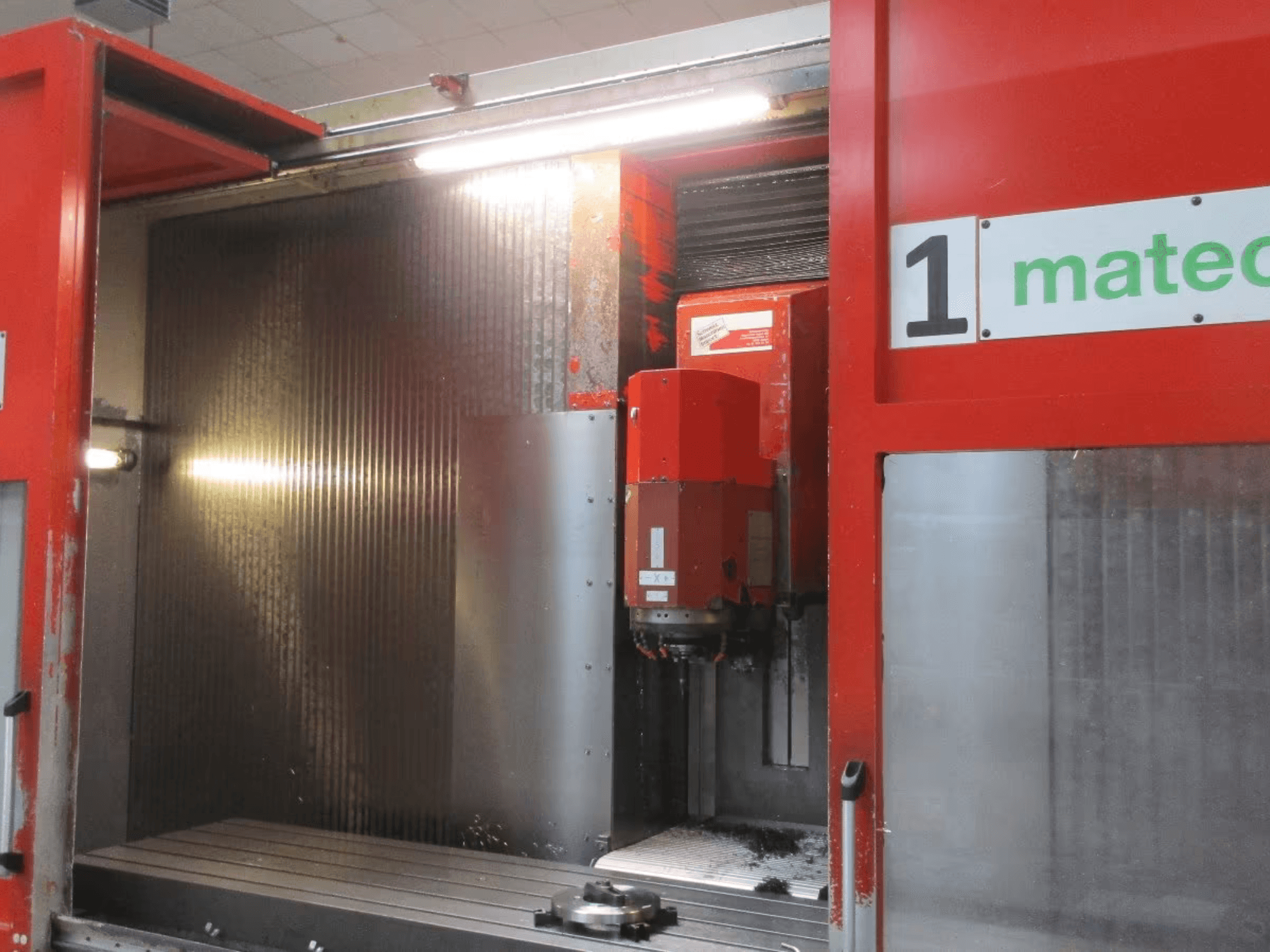 Matec 30 HV CNC vertikaliojo apdirbimo centro vaizdas iš priekio su matomu pjovimo įrankiu, metalo paviršiumi ir staklių vidaus detalėmis.