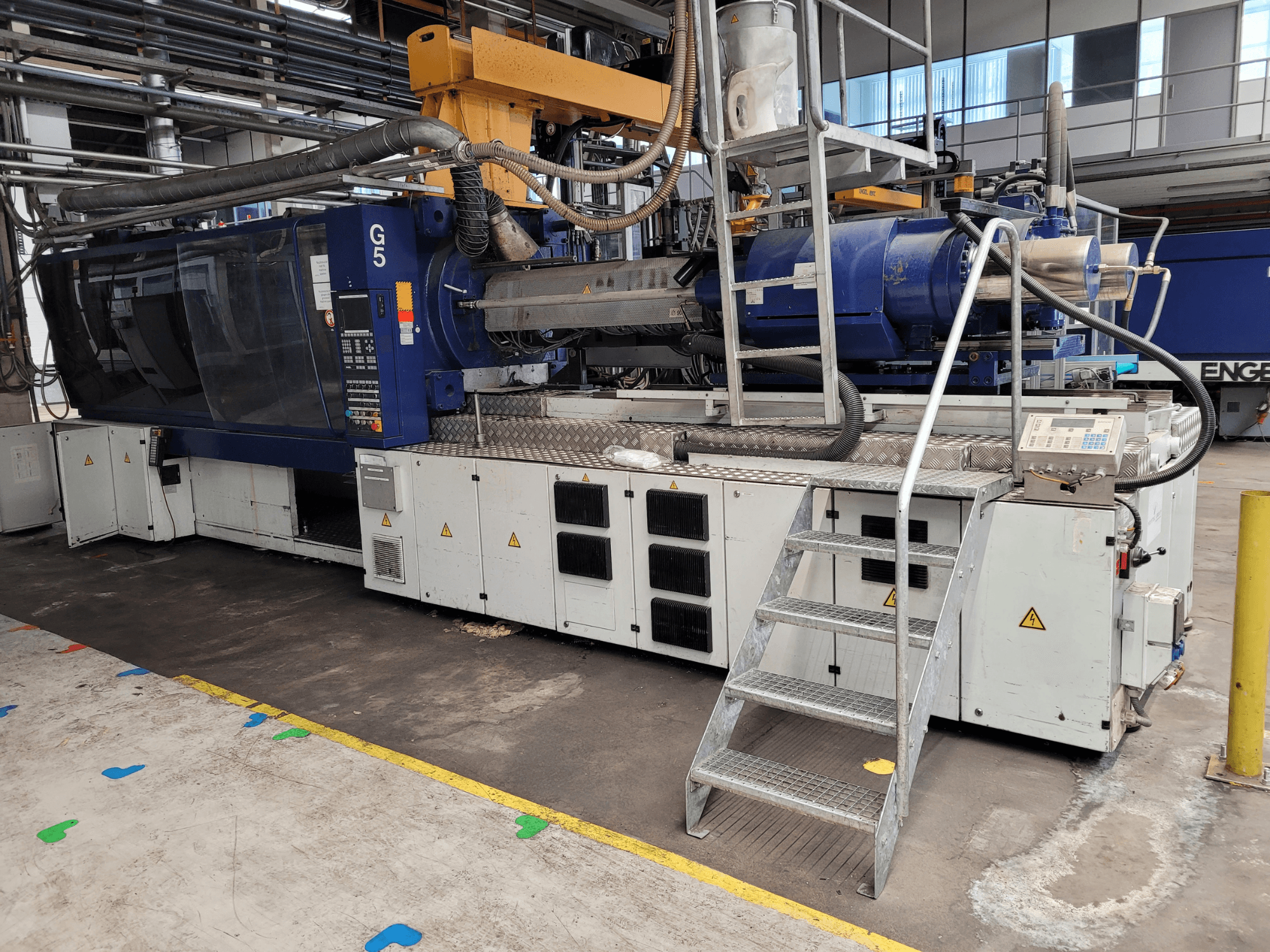 Šoninis vaizdas, kai matomas valdymo skydelis, laiptelinės kopėčios ir nerūdijančio plieno darbo paviršius.