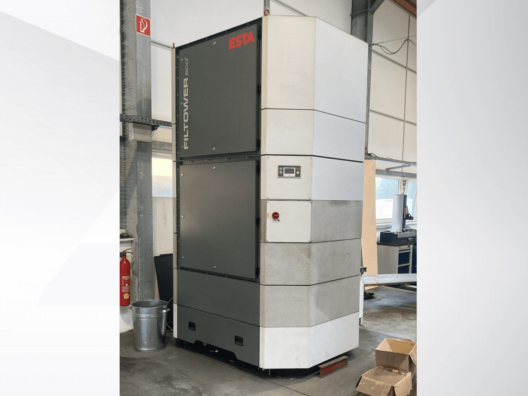 Pilkos ir baltos spalvos "ESTA Filtower eco", vaizdas iš priekio, valdymo skydelis ir ventiliacijos angos. Tinka pramoniniam oro filtravimui.