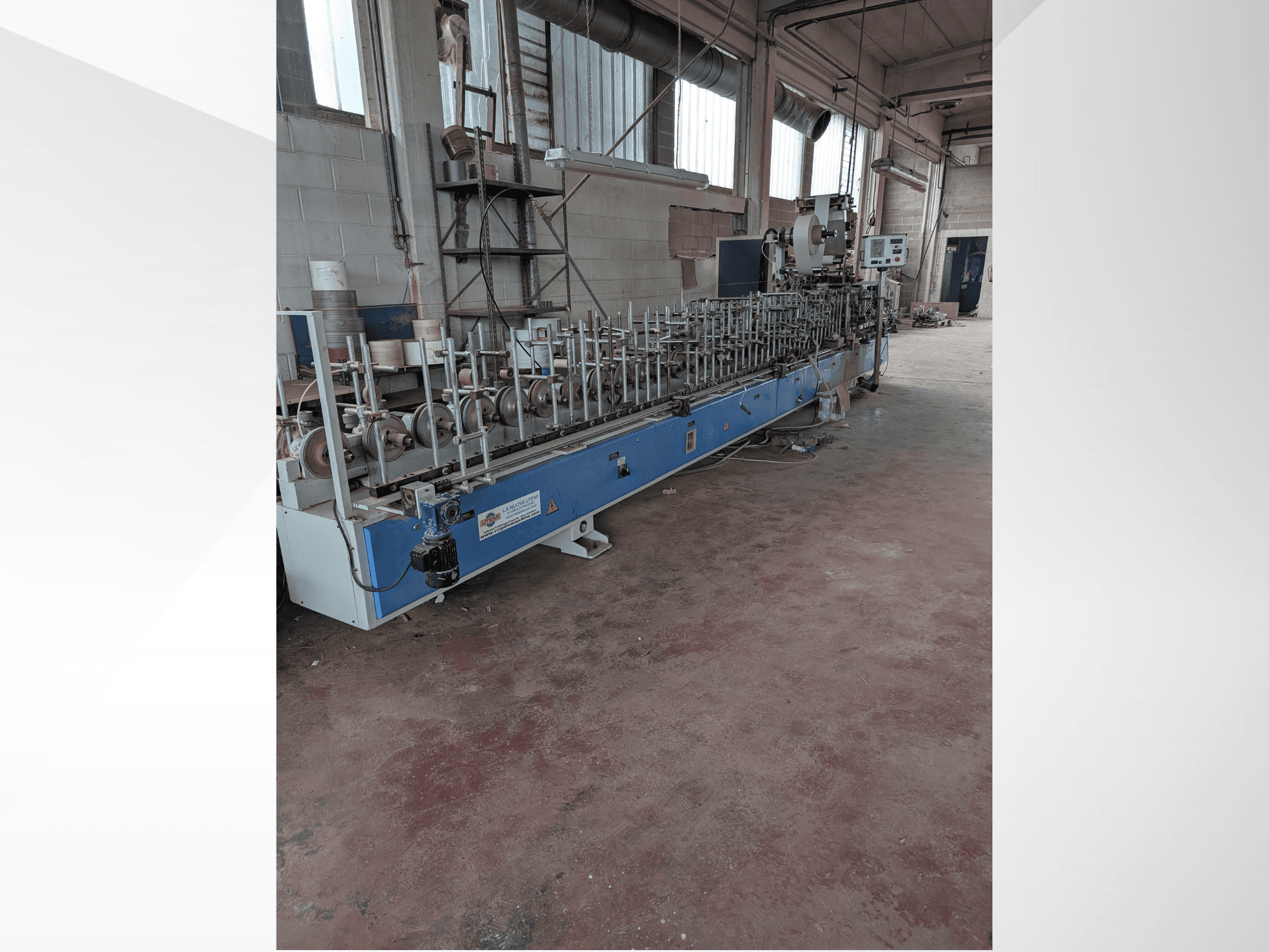 Pramoninėje aplinkoje esančių medienos pjovimo staklių PUR-33-L, turinčių daug verpstukų ir elegantiško mėlyno dizaino, vaizdas iš priekio.