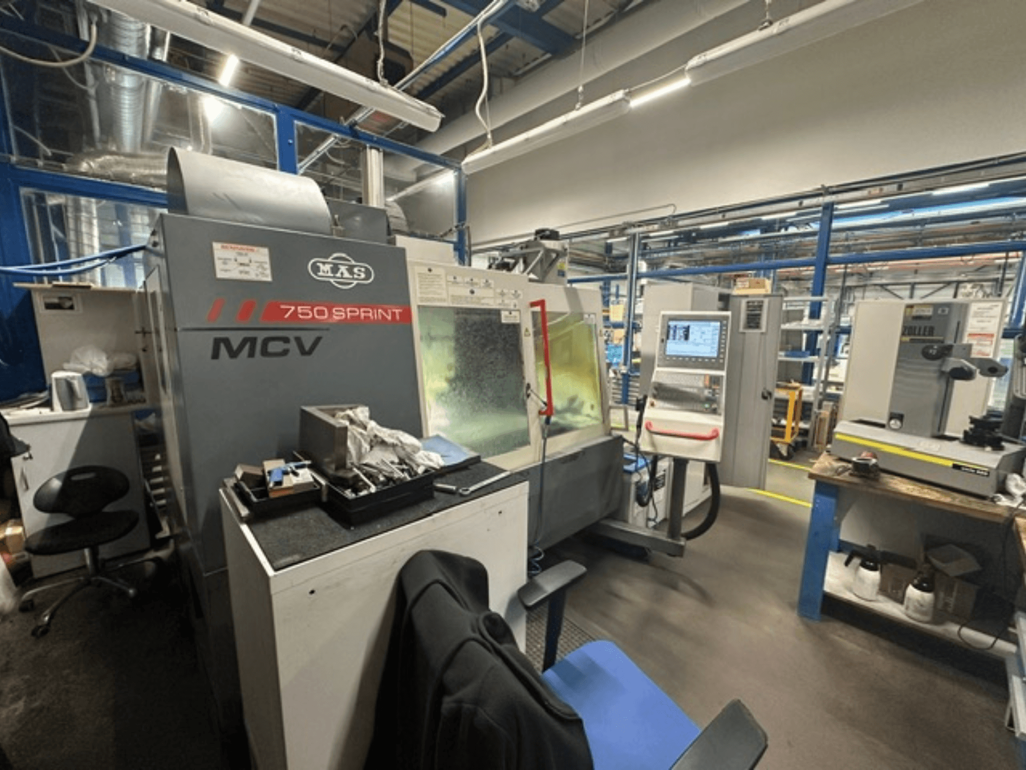 Vertikalus apdirbimo centras „KOVOSVIT MAS MCV 750 Sprint“ dirbtuvėse; nuotraukoje iš šono matomas valdymo pultas ir darbo zona.