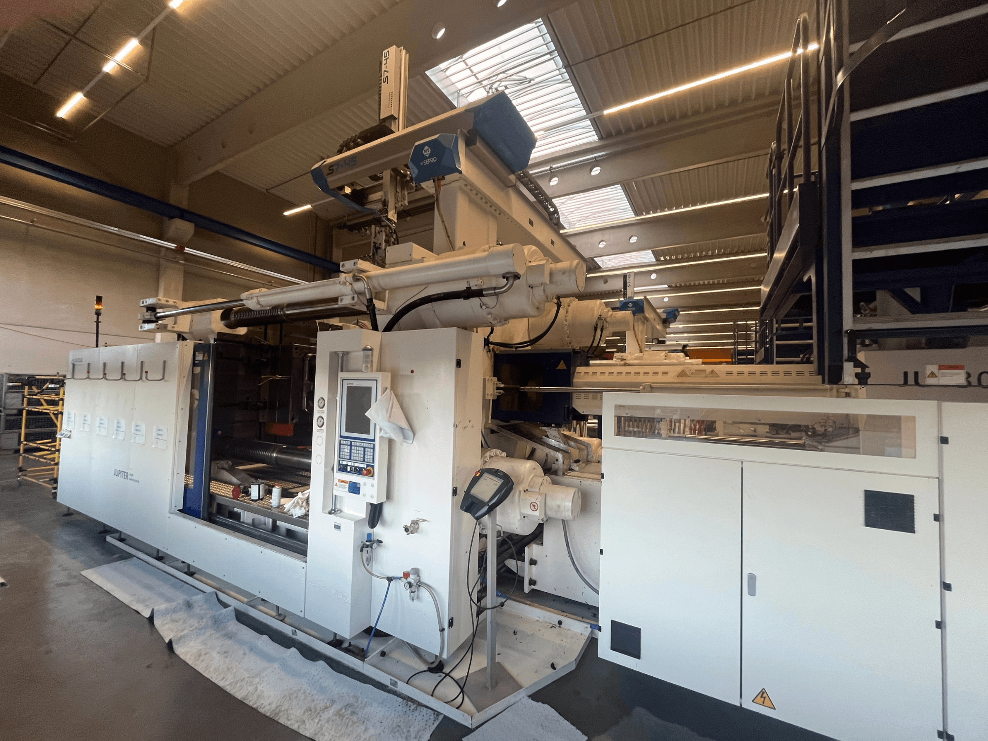 Tekstilės mašinos "Autefa" vaizdas iš priekio, valdymo skydelis, komponentai ir pramoninė aplinka.