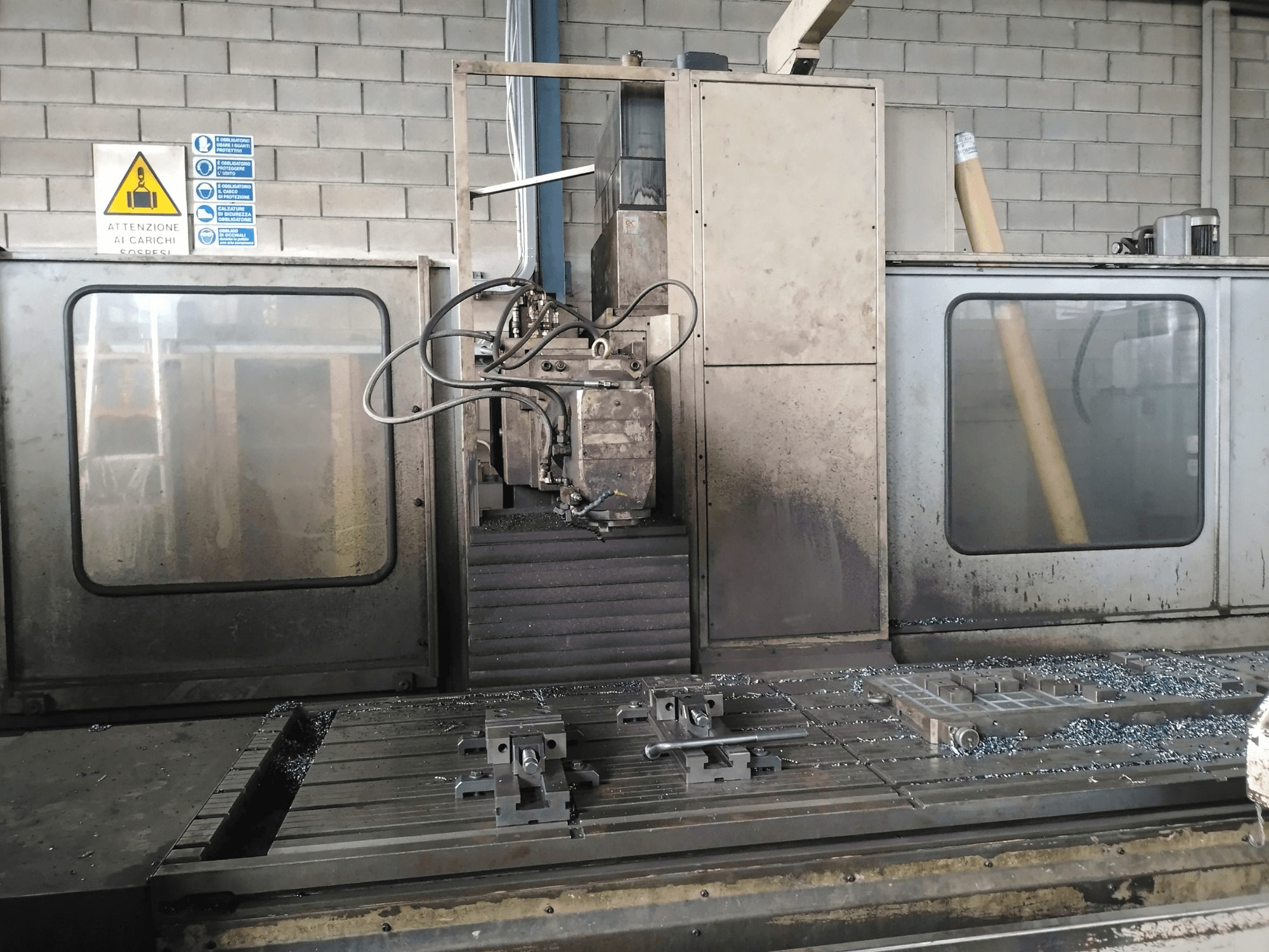 TIGER TFA6 staklės dirbtuvėse, vaizdas iš priekio, ant stalo matomi įrankiai ir metalo drožlės.