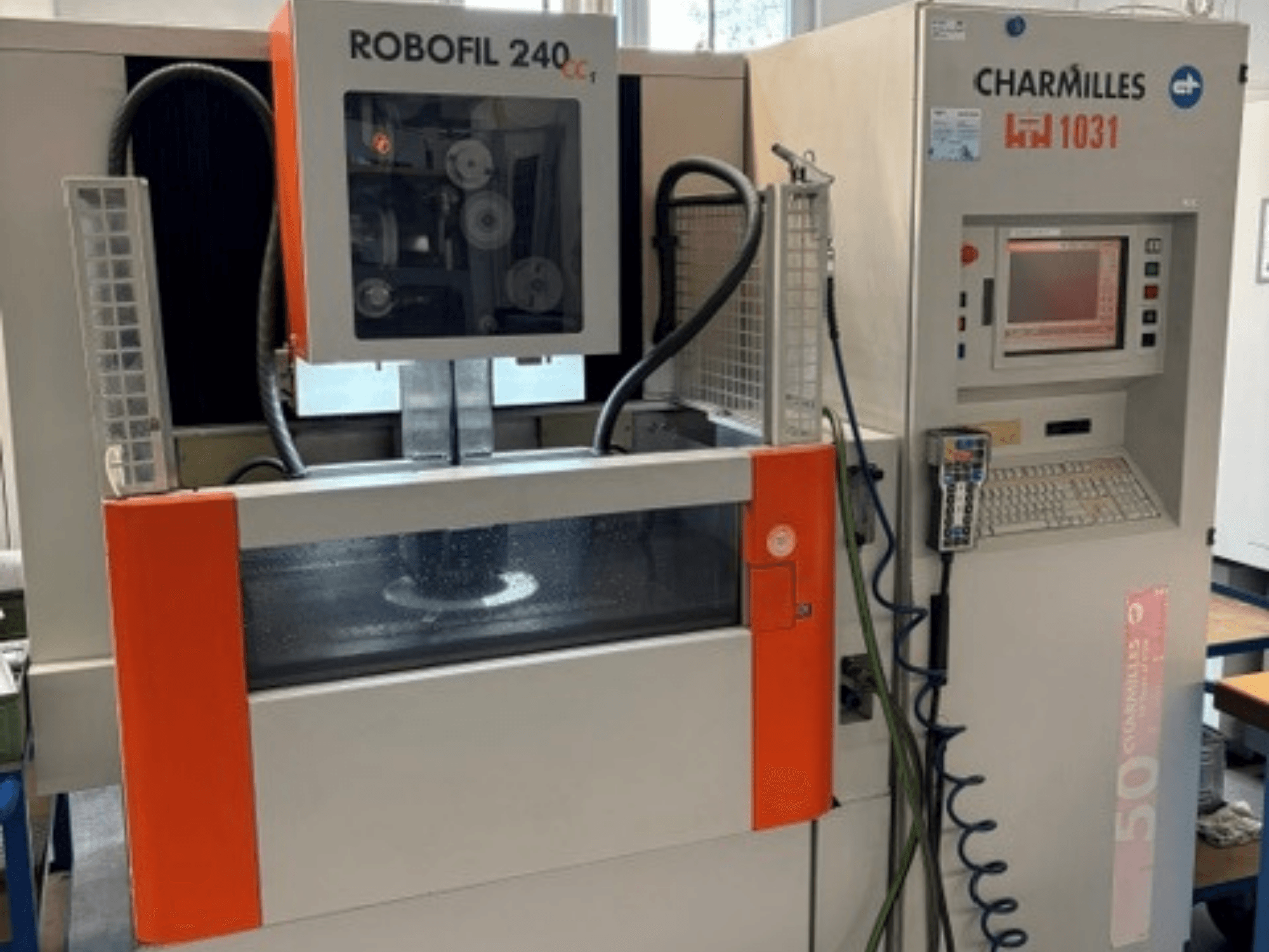 „Charmilles Robofil 240 CC“ vielos elektroerozijos staklės, vaizdas iš priekio, kuriame matomas valdymo skydas ir vandens rezervuaro zona.