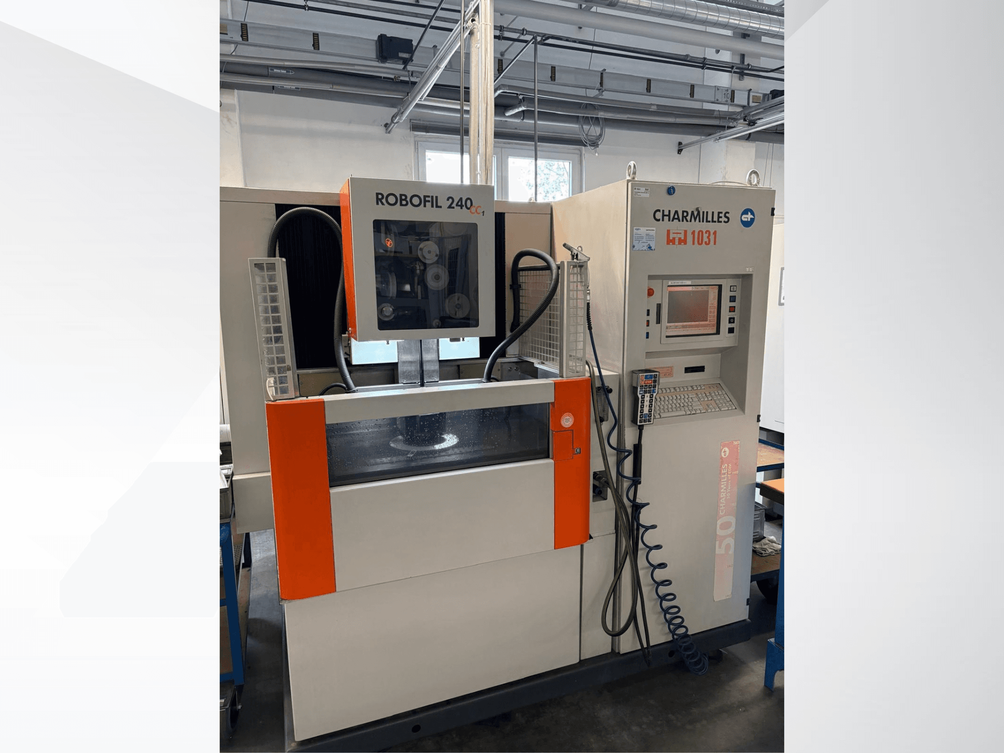 Elektrinės iškrovos apdirbimo (EDM) staklės „CHARMILLES Robofil 240 CC“, vaizdas iš priekio, kuriame matomas valdymo skydas ir vandens bakas su ryškiais oranžiniais akcentais.