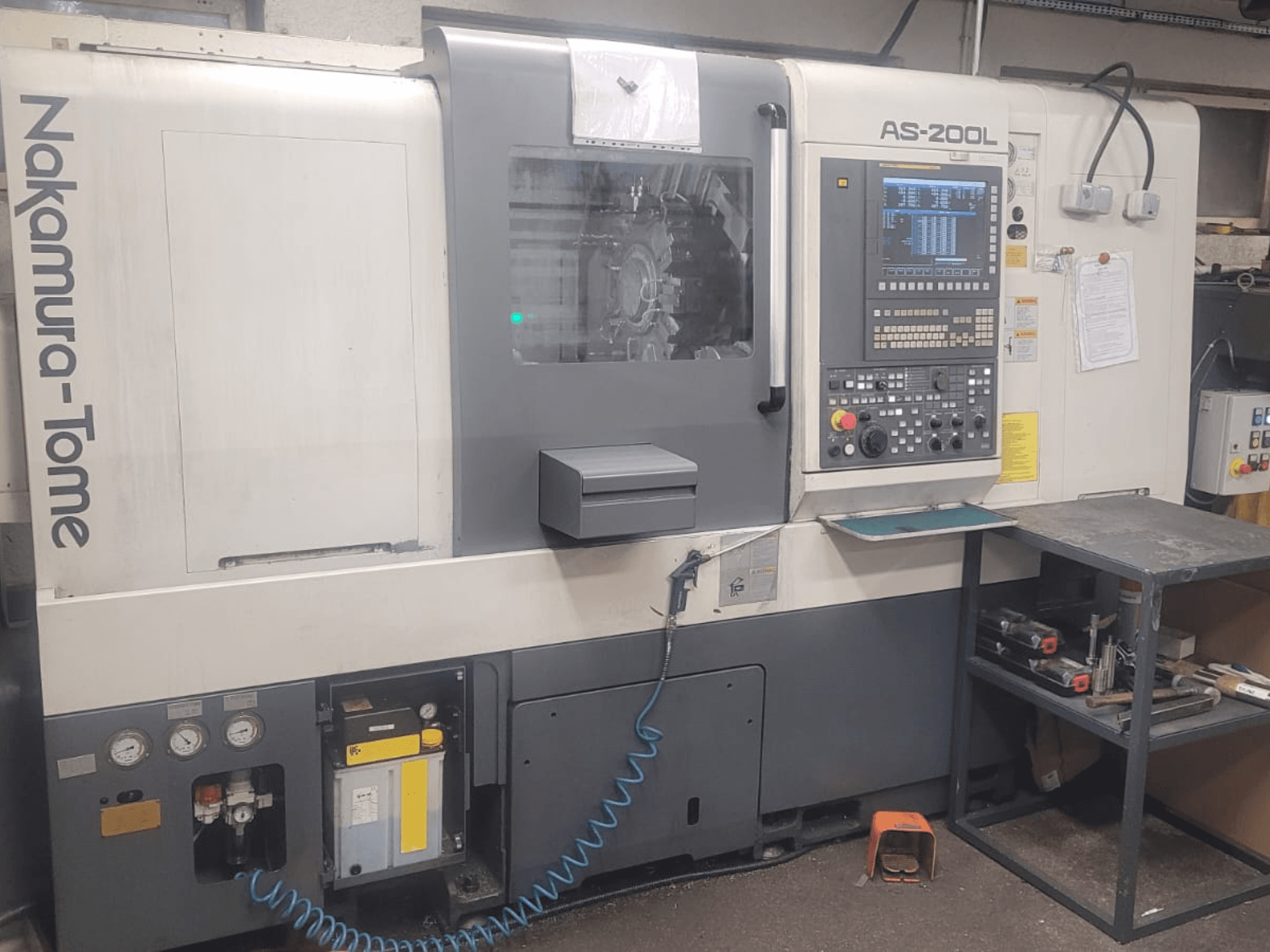 Horizontaliosios tekinimo staklės NAKAMURA-TOME AS-200L, priekinis vaizdas, kuriame matyti valdymo skydelis, suklys ir staklių funkcijos.