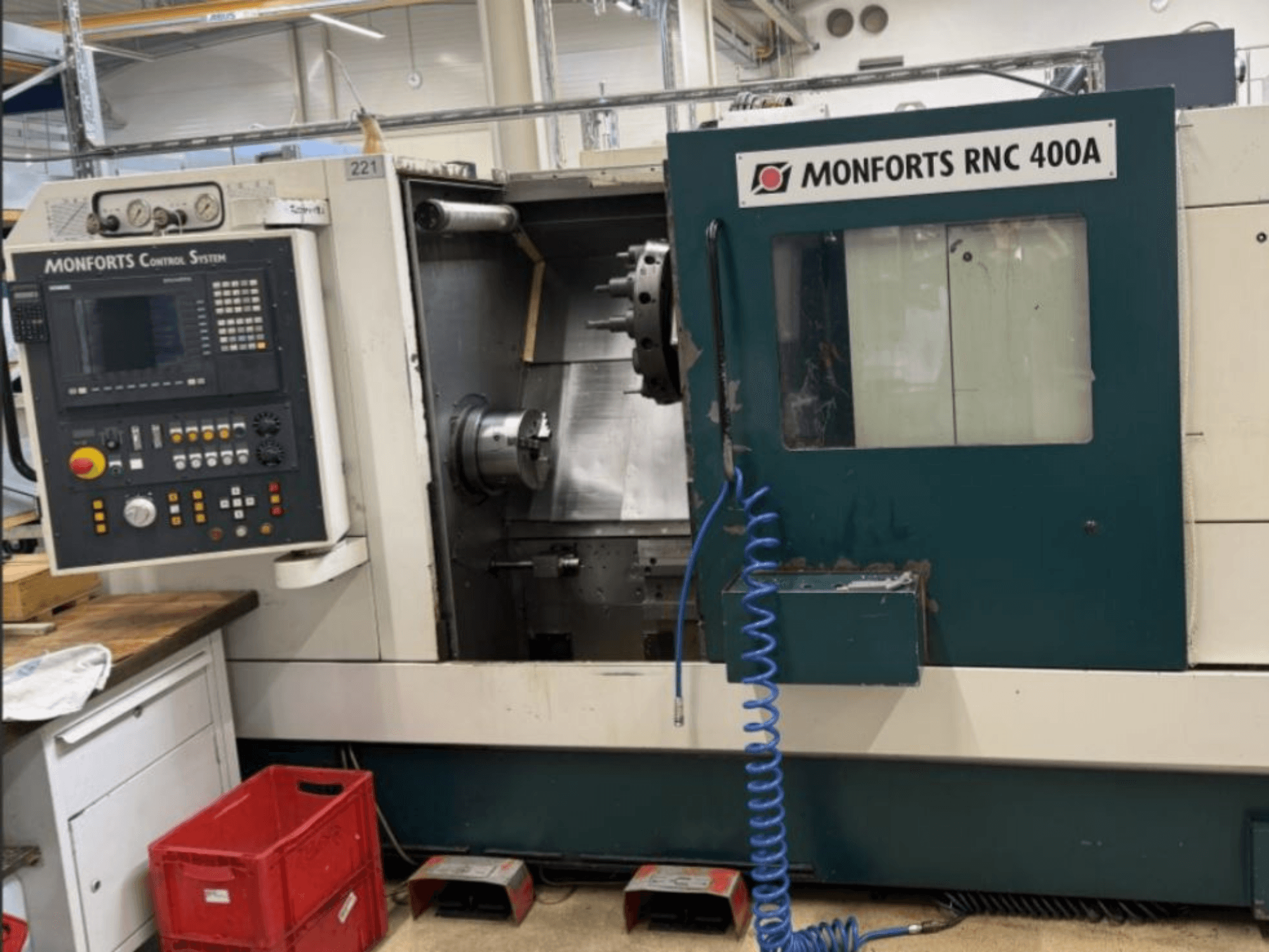 Monforts RNC 400 A horizontalios tekinimo staklės, vaizdas iš priekio, valdymo skydelis ir darbo zona su paryškintomis funkcijomis.