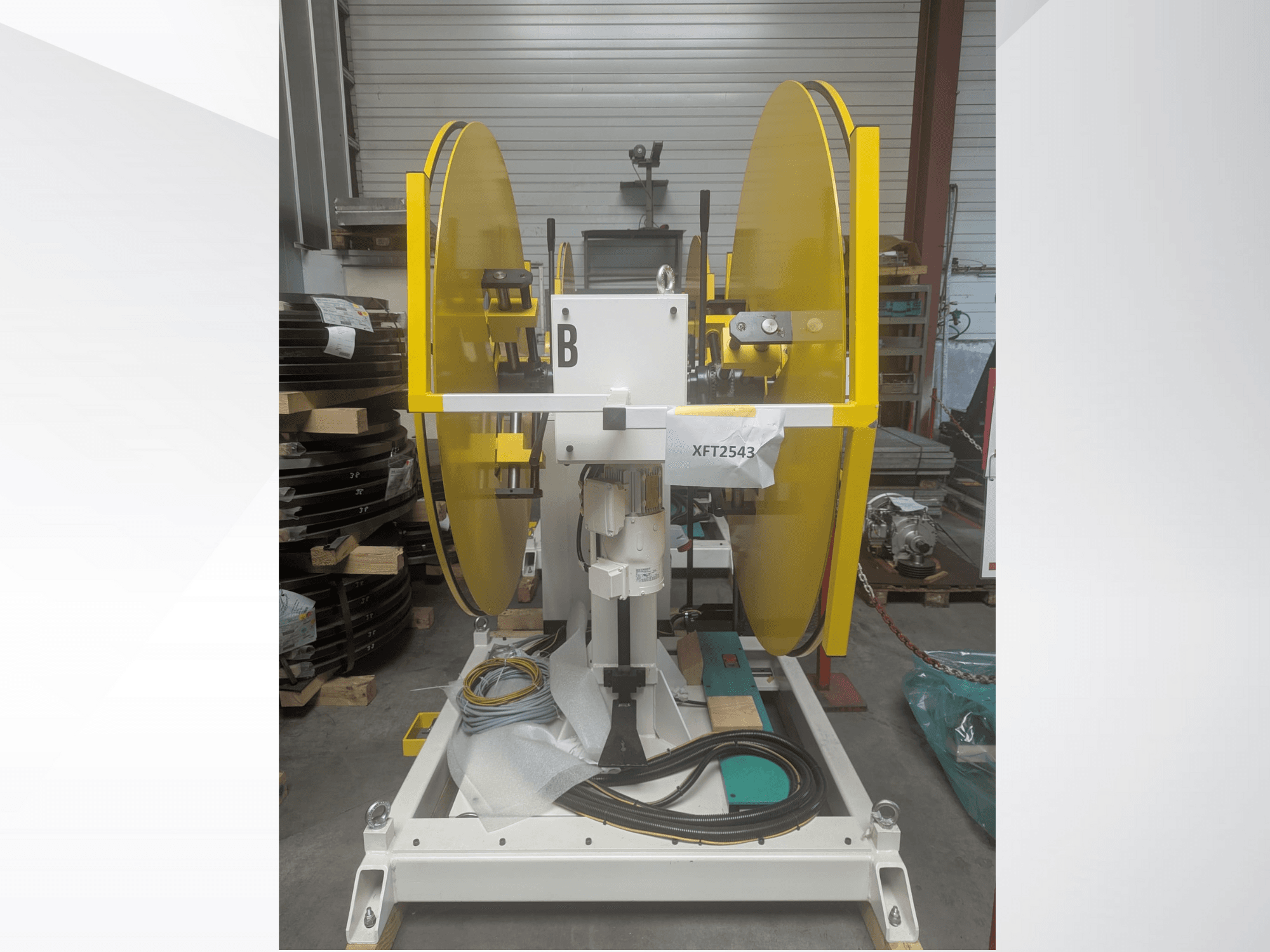 Geltonos spalvos diskinio pjūklo diskai, sumontuoti ant balto mašinos pagrindo, vaizdas iš priekio; XFT2543 modelis, matomi laidai ir sudedamosios dalys.