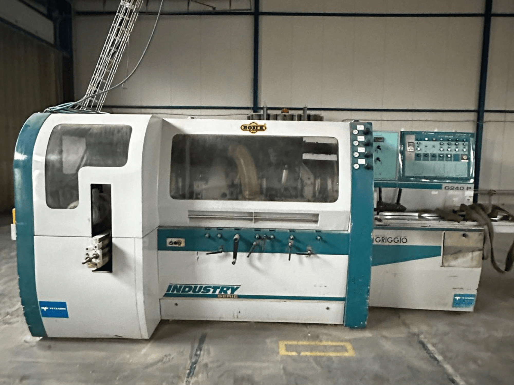 "Griggio Industry G240 P" mašina, vaizdas iš priekio, su valdymo skydeliu ir skaidriu korpusu, iš kurio matyti vidiniai mechanizmai.