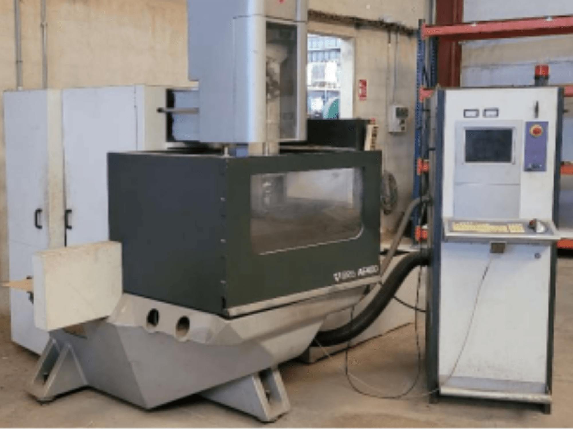 ONA AE 400 vielos EDM staklės dirbtuvėse su valdymo pultu dešinėje ir didele pjovimo zona.