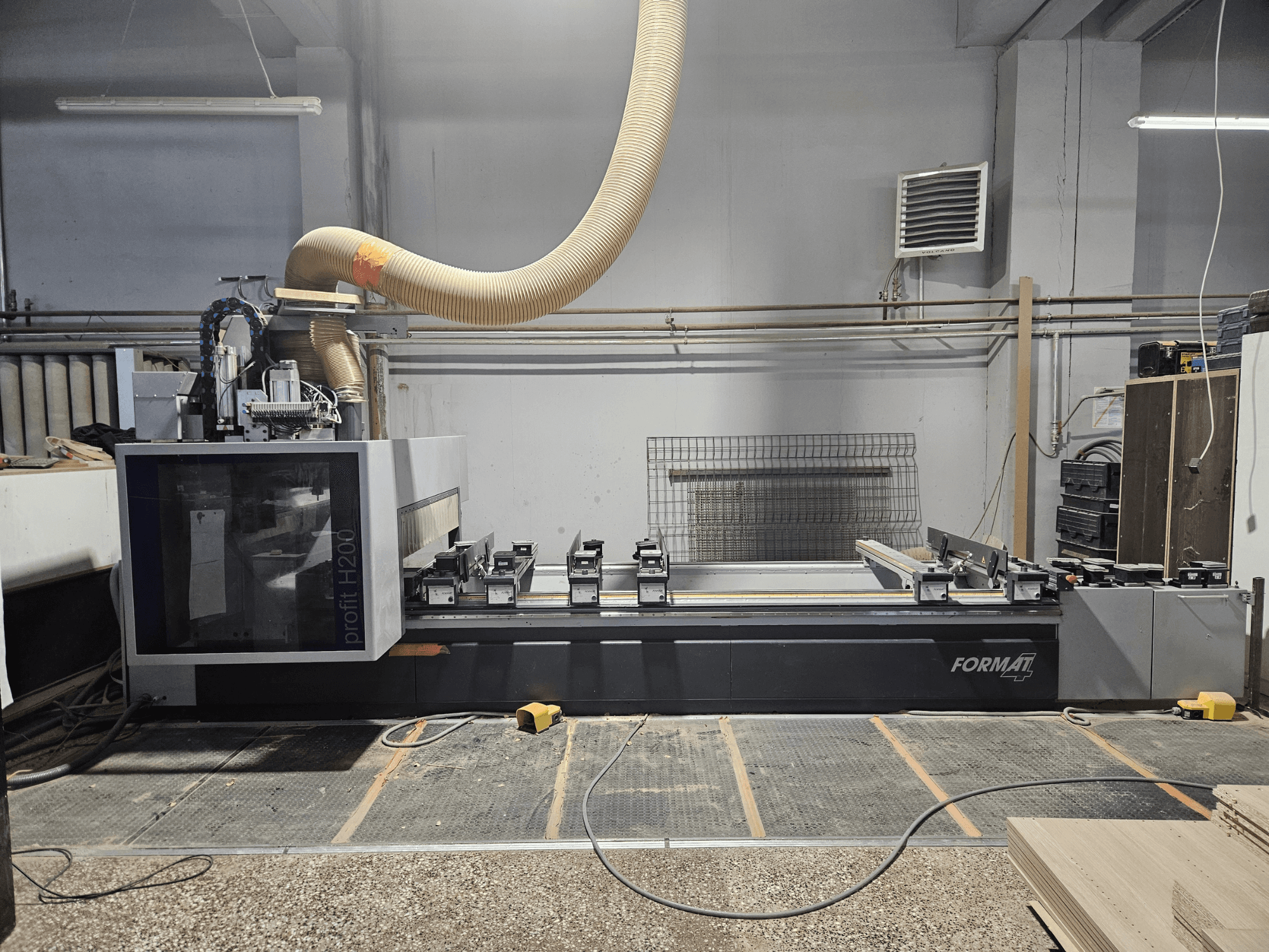 FORMAT profit H200 CNC staklės dirbtuvėse, šoninis vaizdas, kuriame matomas darbo paviršius ir dulkių nusiurbimo sistema.