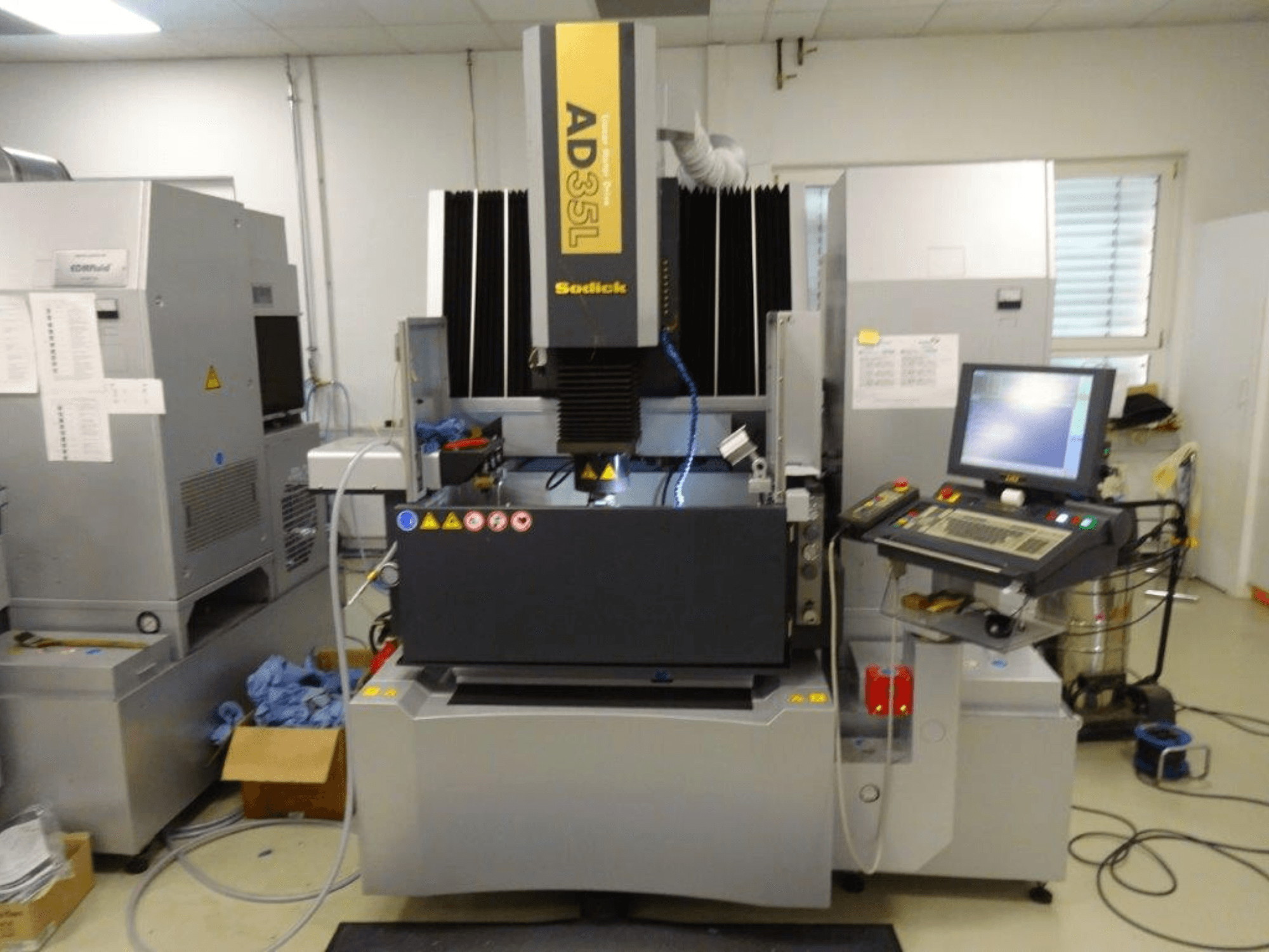 Sodick AD35L elektros iškrovimo mašina, vaizdas iš priekio, matomas valdymo skydelis, aušinimo sistema ir darbo zona.