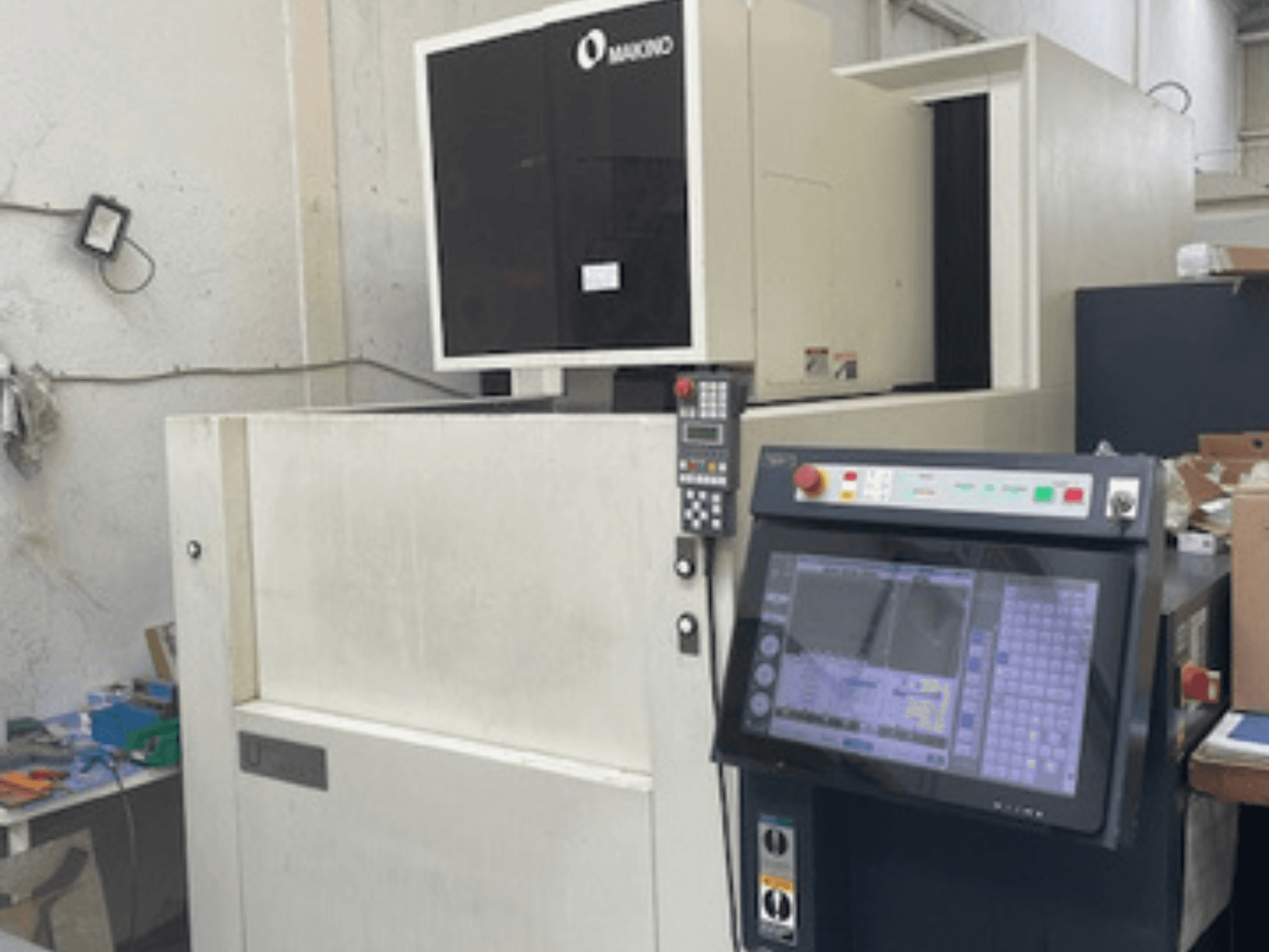 Makino U6 HEAT vielos EDM staklės dirbtuvėse, priekinis vaizdas, kuriame matomas valdymo skydelis ir skaitmeninis ekranas.