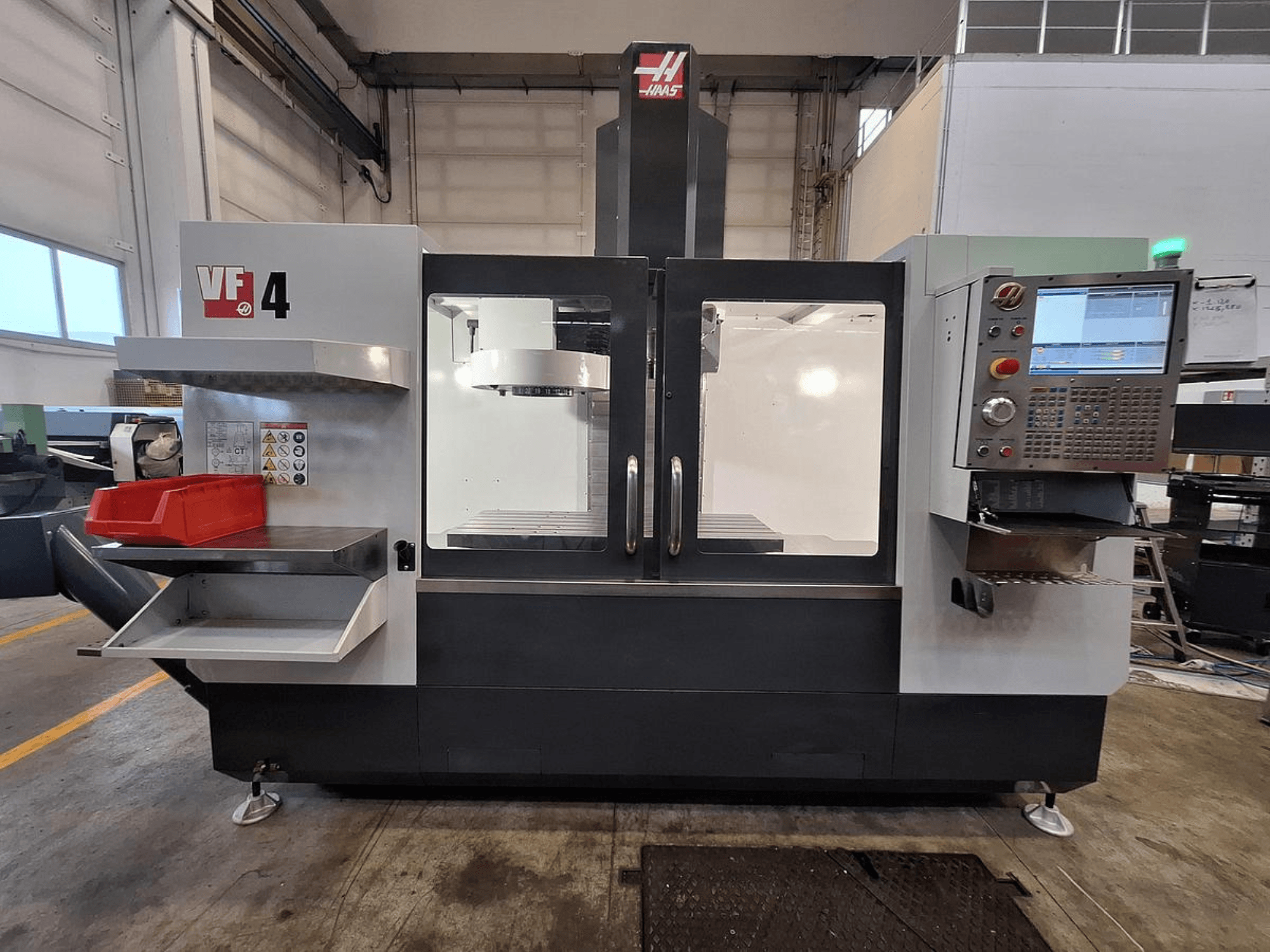 Vertikalaus apdirbimo centro "Haas VF-4" vaizdas iš priekio: valdymo skydelis, įrankių laikiklis ir erdvi darbo zona.