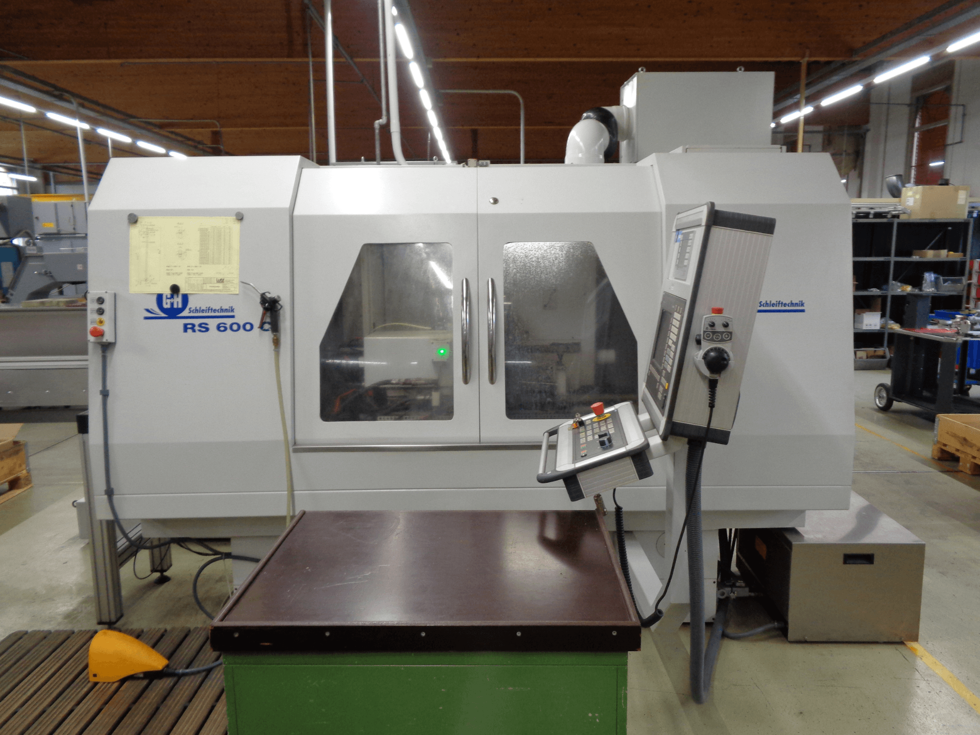 Cilindrinio šlifavimo staklės GEIBEL & HOTZ RS 600 C, priekinis vaizdas, kuriame matomas valdymo skydelis ir darbo stalas gamykloje.