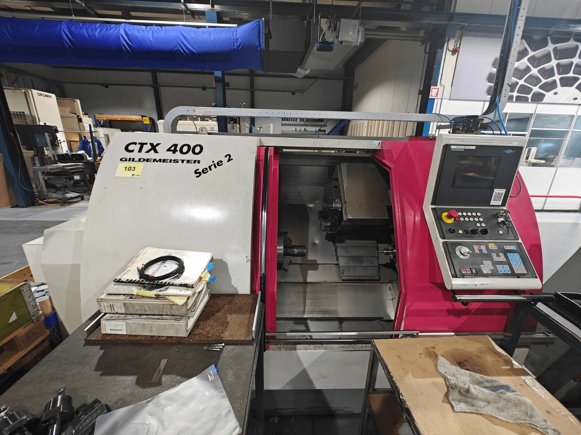 CTX 400 "Gildemeister" tekinimo staklės, parodytos iš priekio, su valdymo skydeliu su mygtukais, ekranu ir darbo vieta.