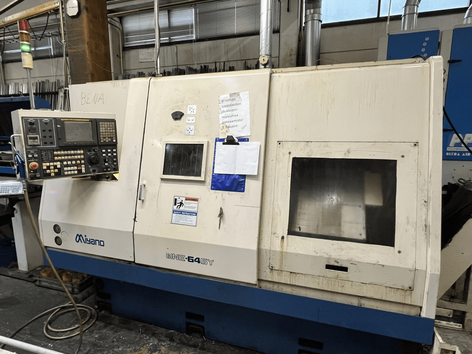 Miyano BNE-64SY CNC tekinimo staklės, vaizdas iš priekio, valdymo skydelis su mygtukais, skystųjų kristalų ekranas ir techninės priežiūros lipdukai ant korpuso.