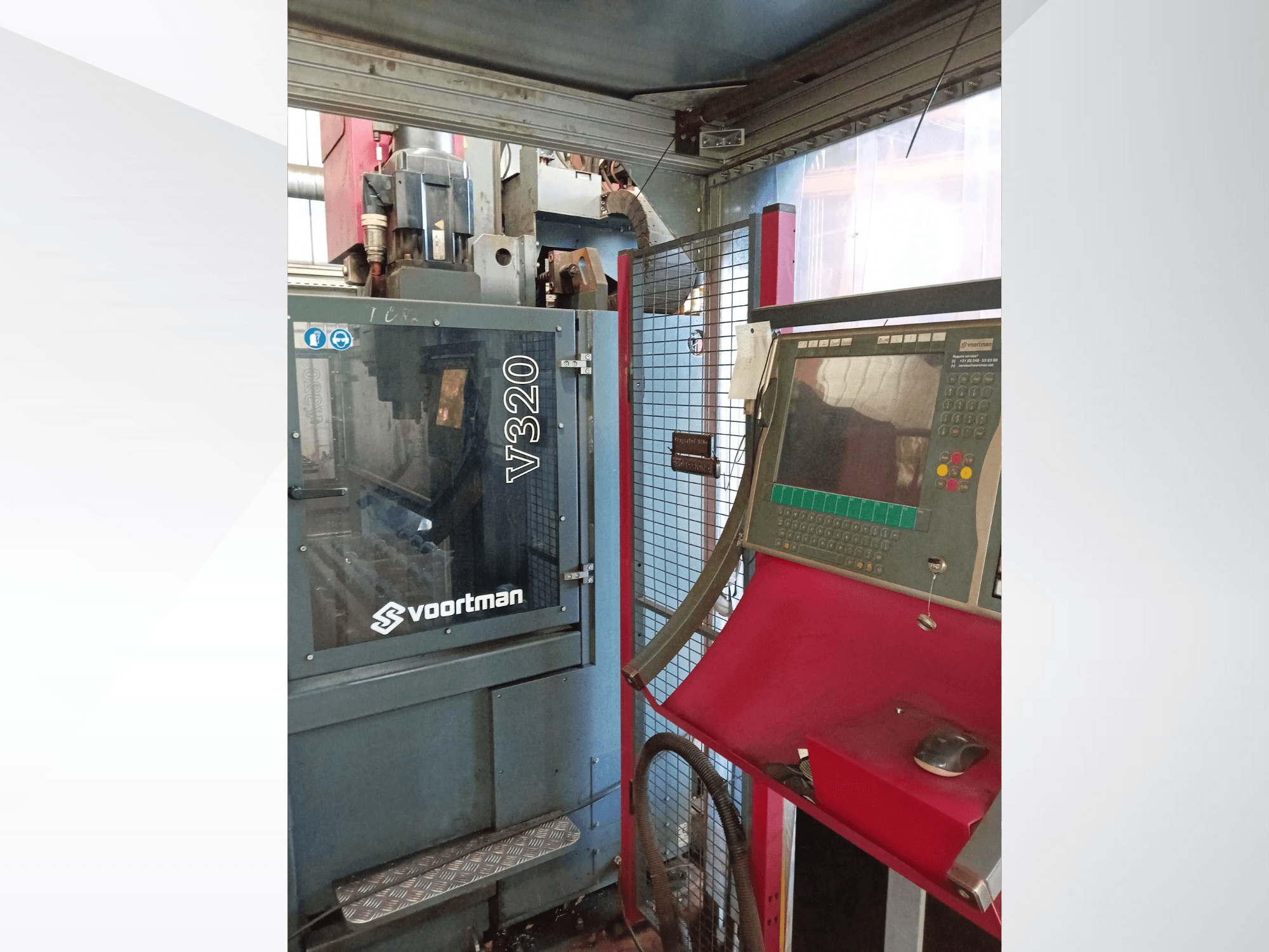 Voortman V320 CNC staklių priekinis vaizdas, kuriame matomas valdymo skydelis su mygtukais, ekranas ir apsauginis tinklinis gaubtas.