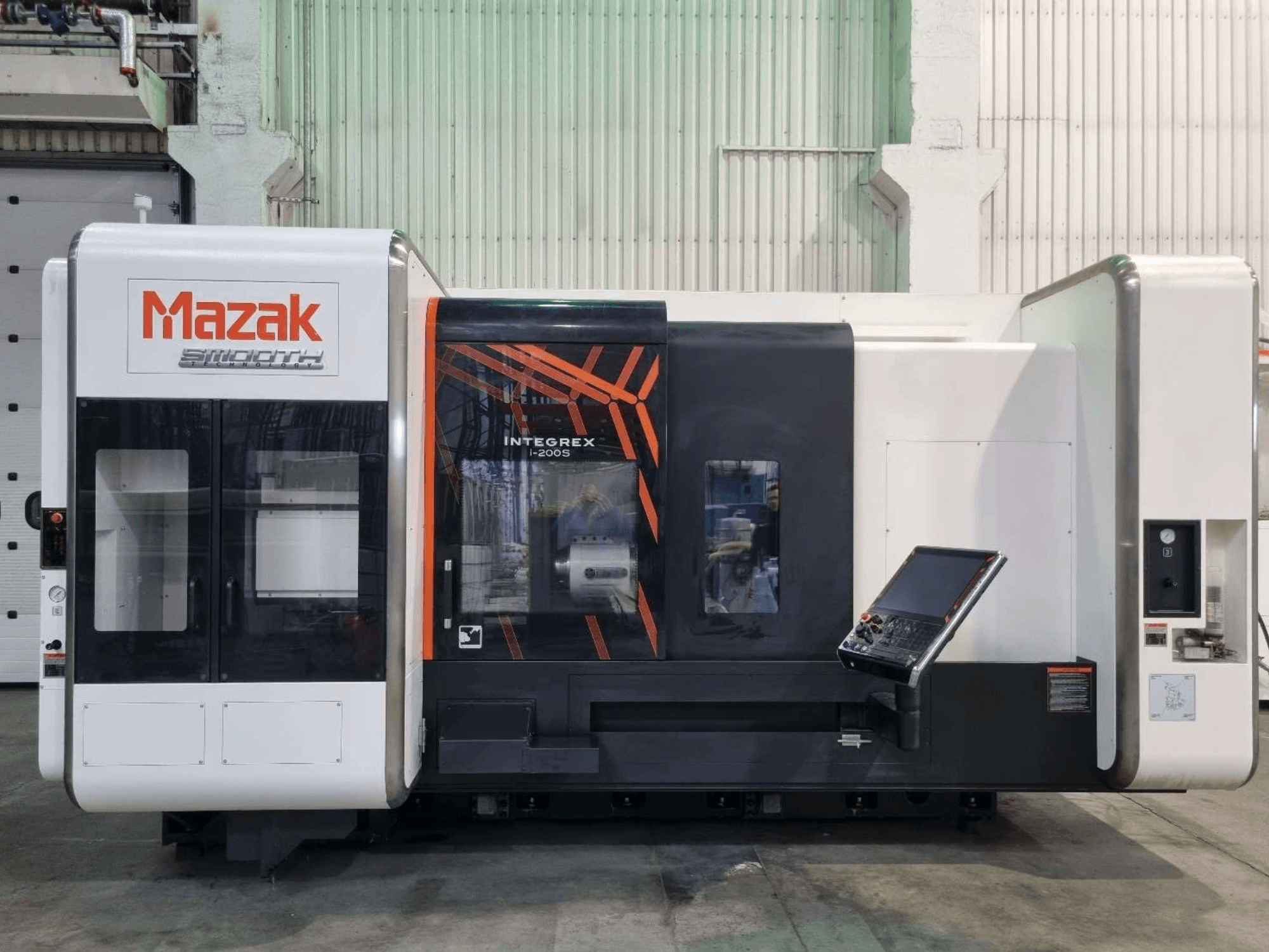 "Mazak INTEGREX i-200 S" tekinimo frezavimo centras, vaizdas iš priekio, su valdymo skydeliu ir dideliu langu, pro kurį matyti apdirbimo zona.