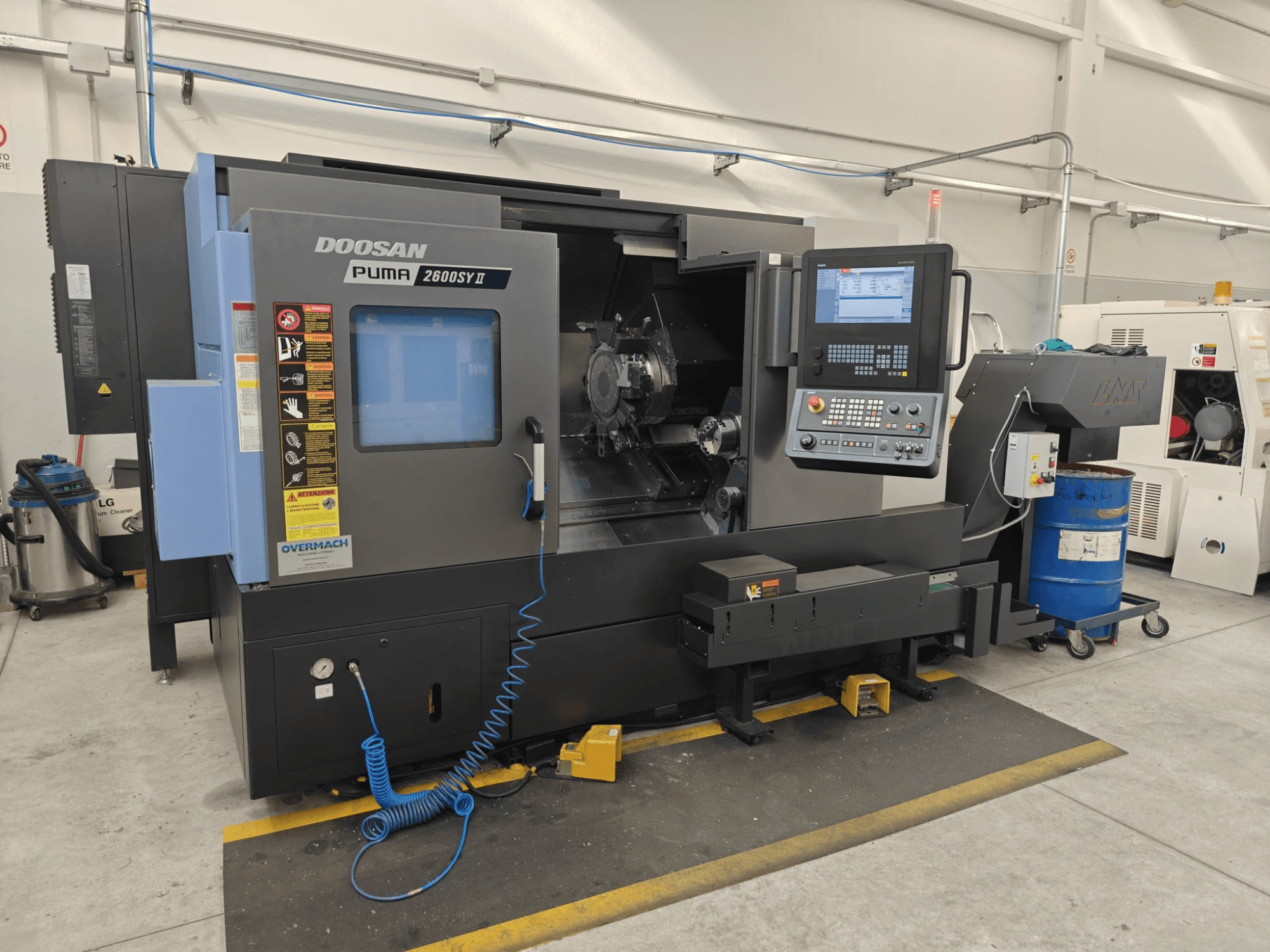 „DOOSAN Puma 2600 SY II“ horizontalioji tekinimo staklė, vaizdas iš priekio, su valdymo pultu ir veikimo indikatoriais.