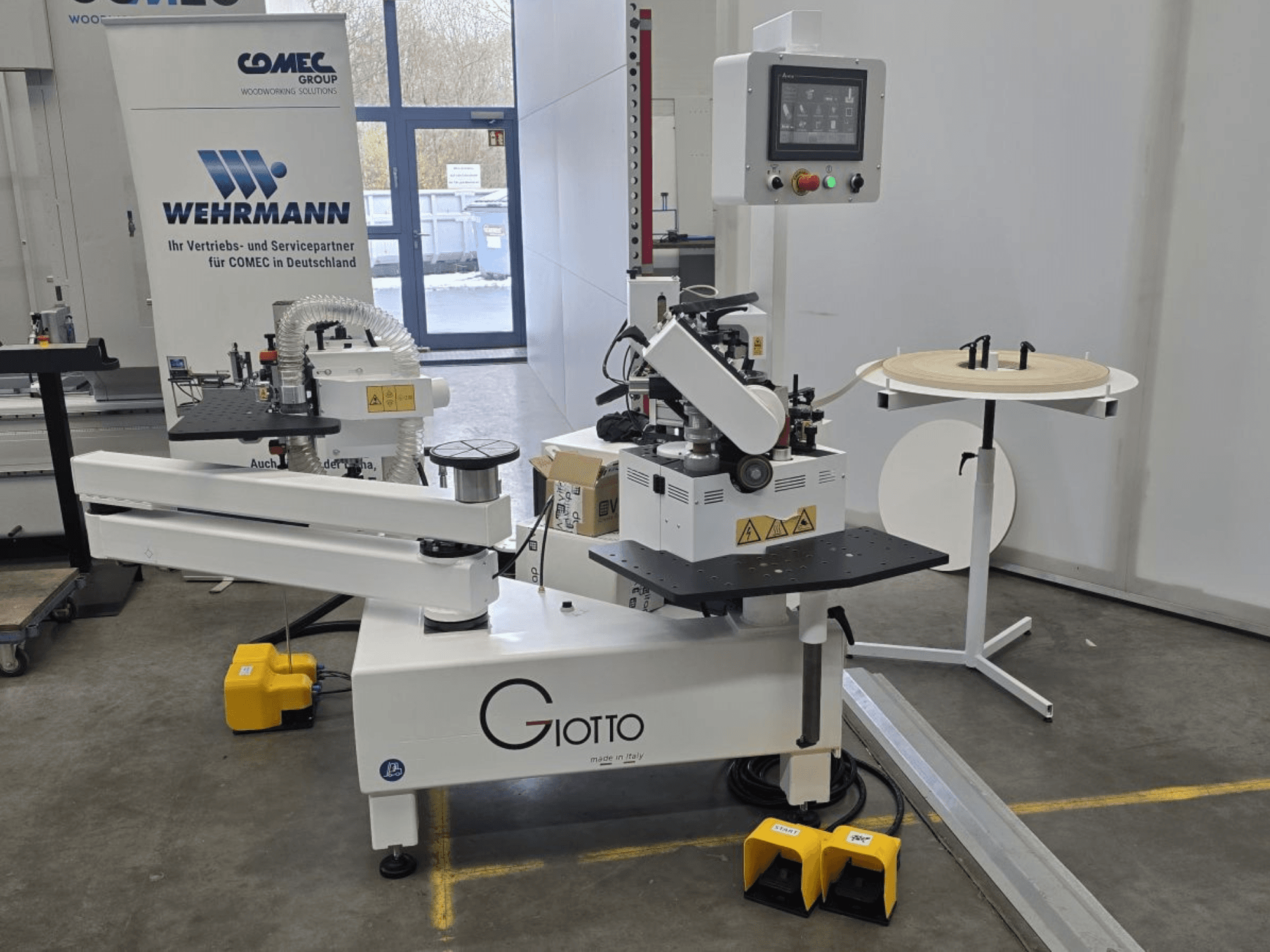 Medienos apdirbimo staklės "Giotto" su valdymo skydeliu, vaizdas iš šono, su kojiniais pedalais ir besisukančiu darbiniu paviršiumi.