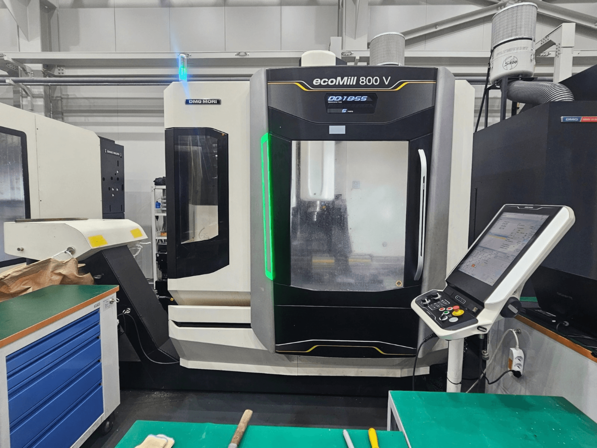 Vertikalusis apdirbimo centras „DMG MORI ecoMill 800 V“, vaizdas iš priekio, kuriame matomas valdymo pultas ir staklių detalės.