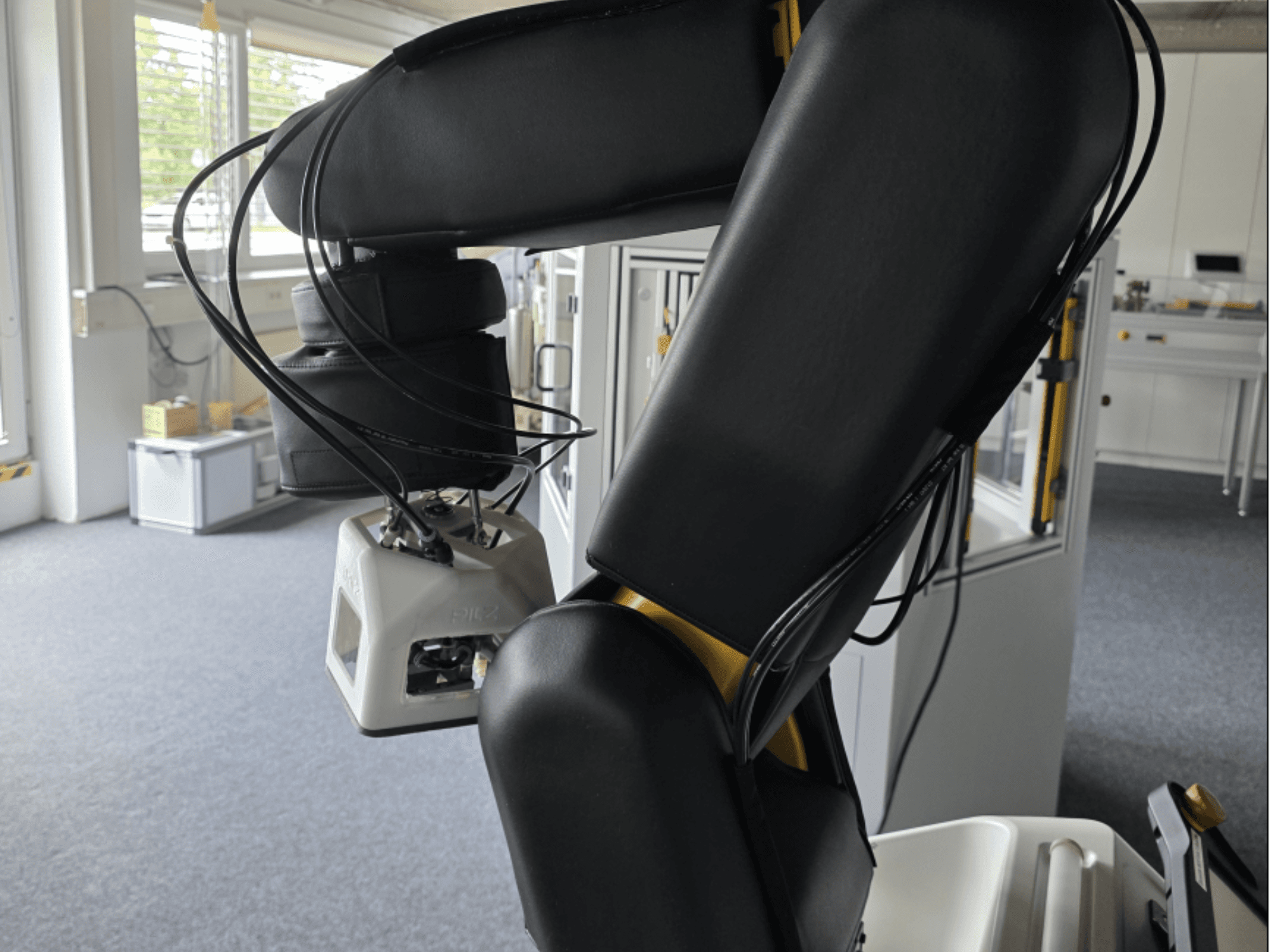 „FANUC LR Mate 200iD/7L“ bendradarbiaujančio roboto vaizdas iš šono, kuriame matoma ranka ir jutikliai, o dirbtuvėse matomi kabeliai.