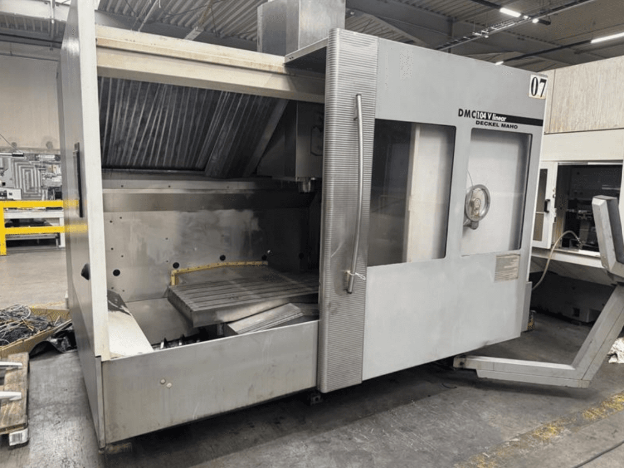 Deckel Maho linijinės staklės DMC 104 V, vaizdas iš priekio, tuščia apdirbimo zona su dideliu darbo stalu.