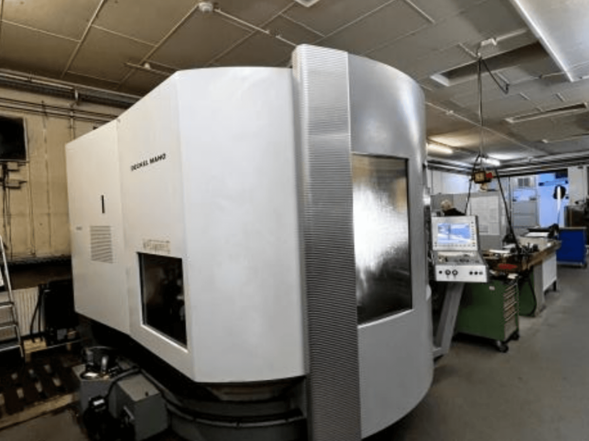 SODICK MAKO CNC staklės dirbtuvėse, vaizdas iš šono, fone matomas valdymo pultas ir darbo zona.