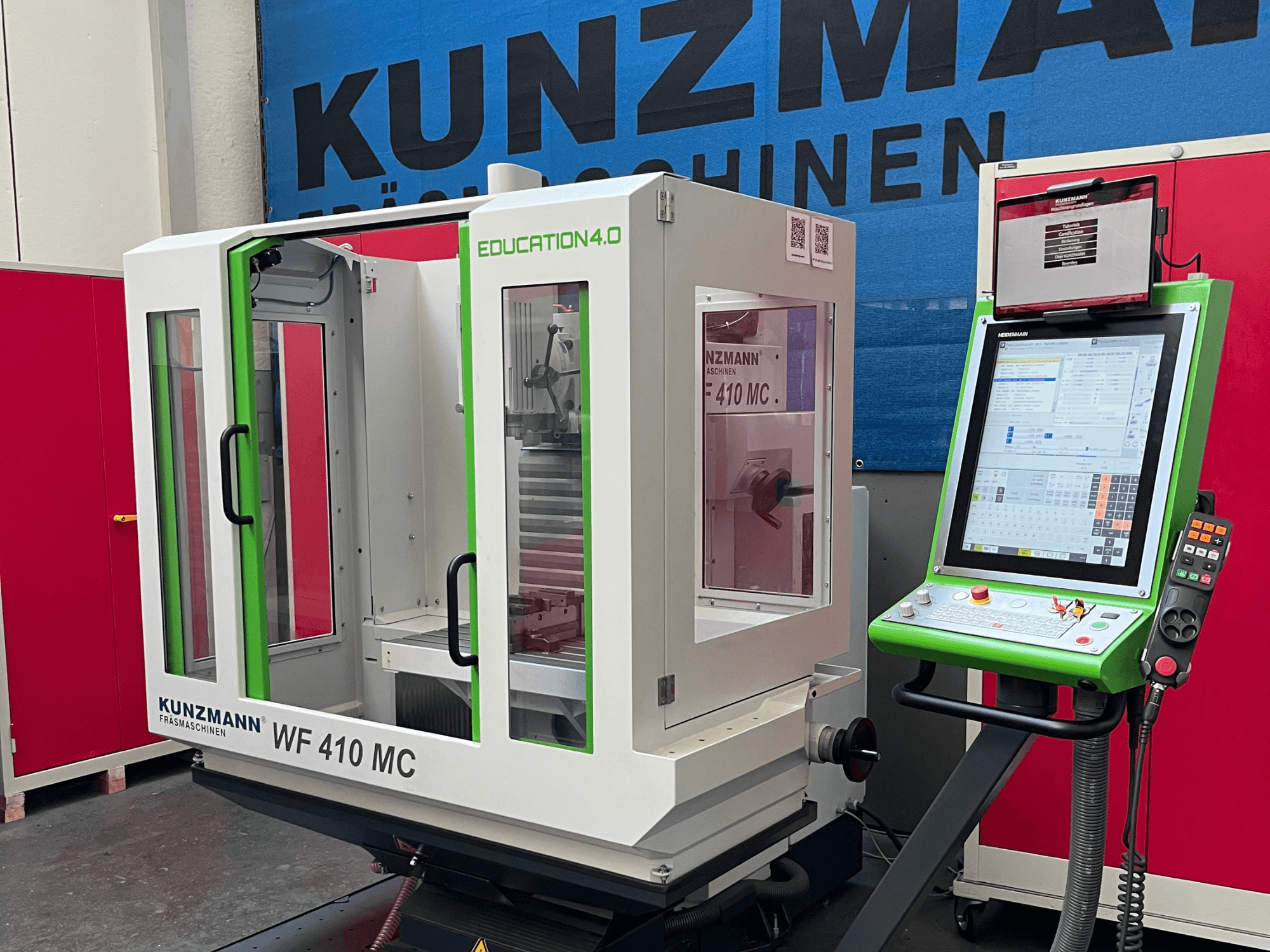 Universalus apdirbimo centras „KUNZMANN WF 410 MC“, vaizdas iš priekio, kuriame matomi žali akcentai, permatomos durelės ir valdymo pultas.