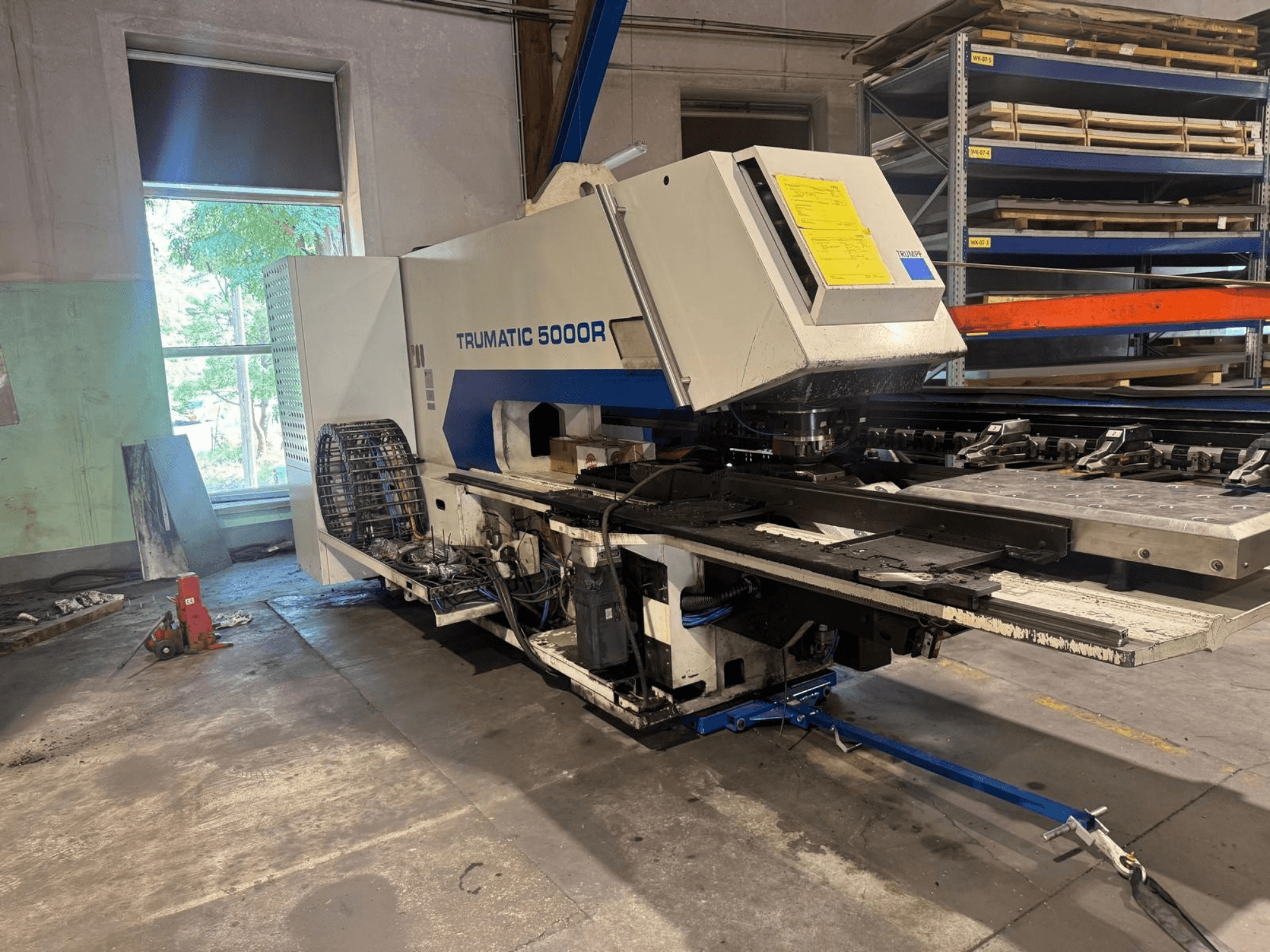 CNC štampavimo staklės „TRUMPF TRUMATIC 5000R“ dirbtuvėse, vaizdas iš priekio, kuriame matomi valdymo elementai ir štampavimo zona.