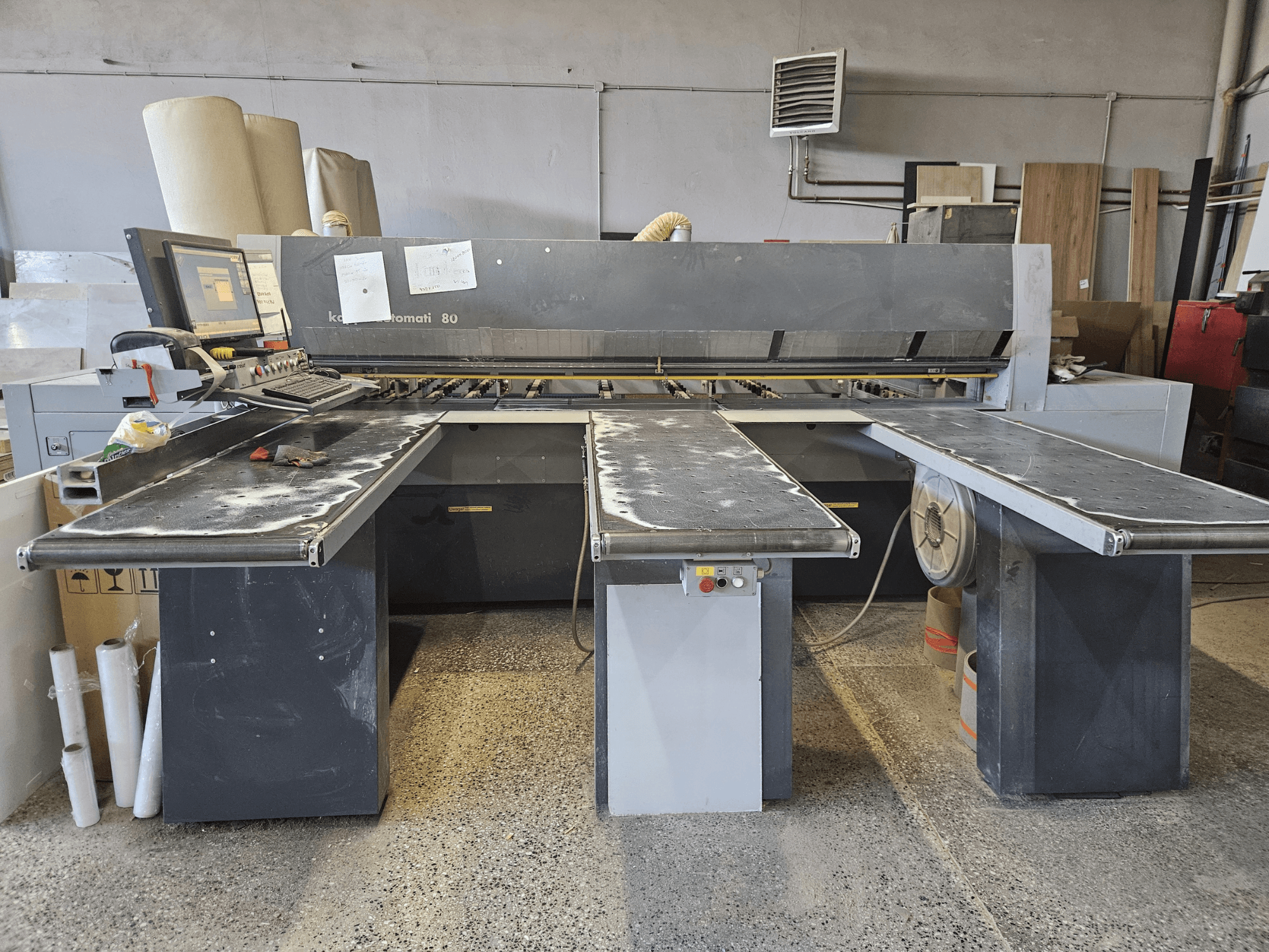 KAPPA Automati 80 staklės, vaizdas iš priekio, trys plokšti stalai, valdymo pultas, ant paviršių išsibarsčiusios pjuvenos.