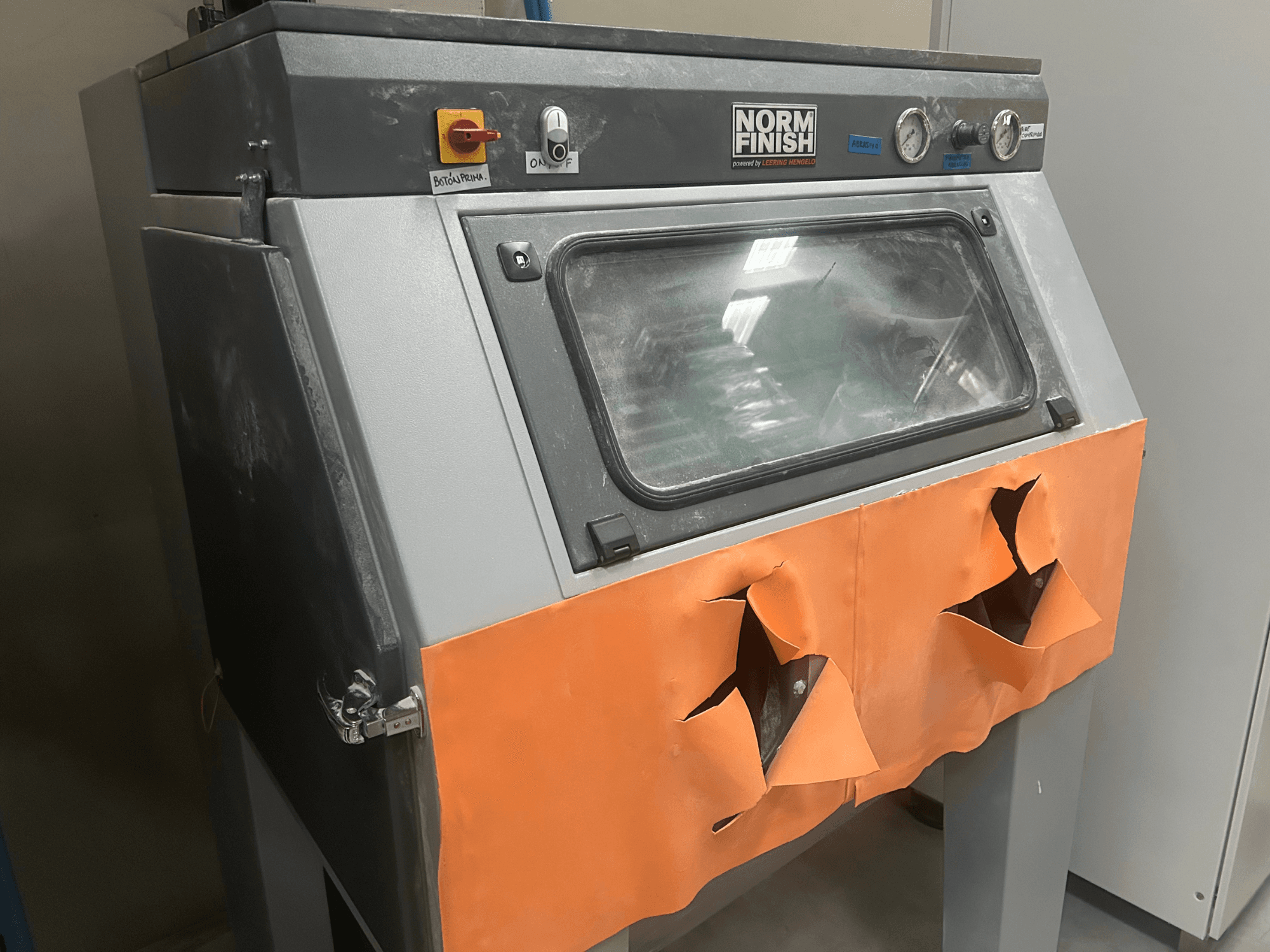 Pilkos spalvos plastikinis 3D spausdintuvas "EOS P 396", vaizdas iš šono, nusidėvėjęs oranžinis dangtelis ir matomas valdymo skydelis, dulkėtas.
